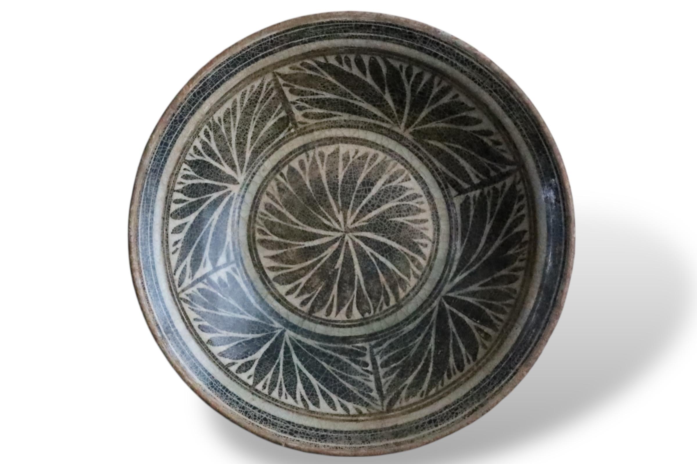 Raro plato de cerámica antigua procedente de los hornos de Kalong, en el norte de Tailandia, que data de los siglos XV-XVI (periodo Lan Na). Esta pieza presenta un característico vidriado marrón hierro con motivos florales o foliados radiantes, una