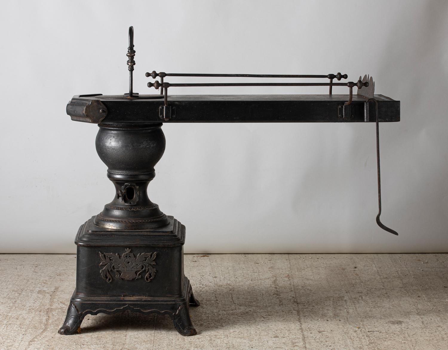 Ironer pan with side body in cast iron and sheet iron.
Chimney flue making a heating table, France, end of the 19th century.

Measures: The base with the fireplace measures 20.1 in wide by 20.1 in deep.
The table measures 48.43 in long by 16.14
