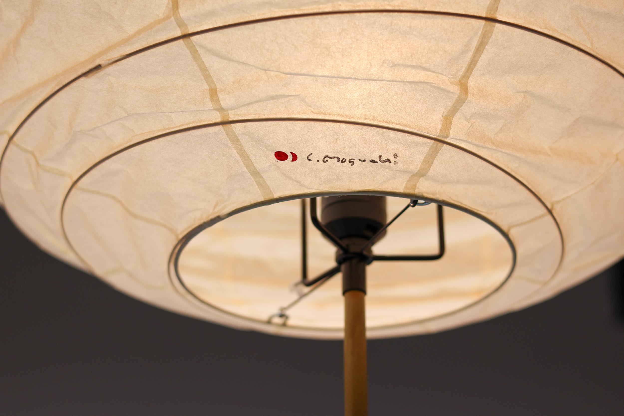 Poetic Isamu Noguchi Akari floor lamp, model BB3-55DD. 
Cast iron base with bamboo stem and a handmade washi paper shade. 
Marked with Noguchi signature and trademark red symbol on the shade.
In pristine condition.

Akari Light Sculptures by Isamu