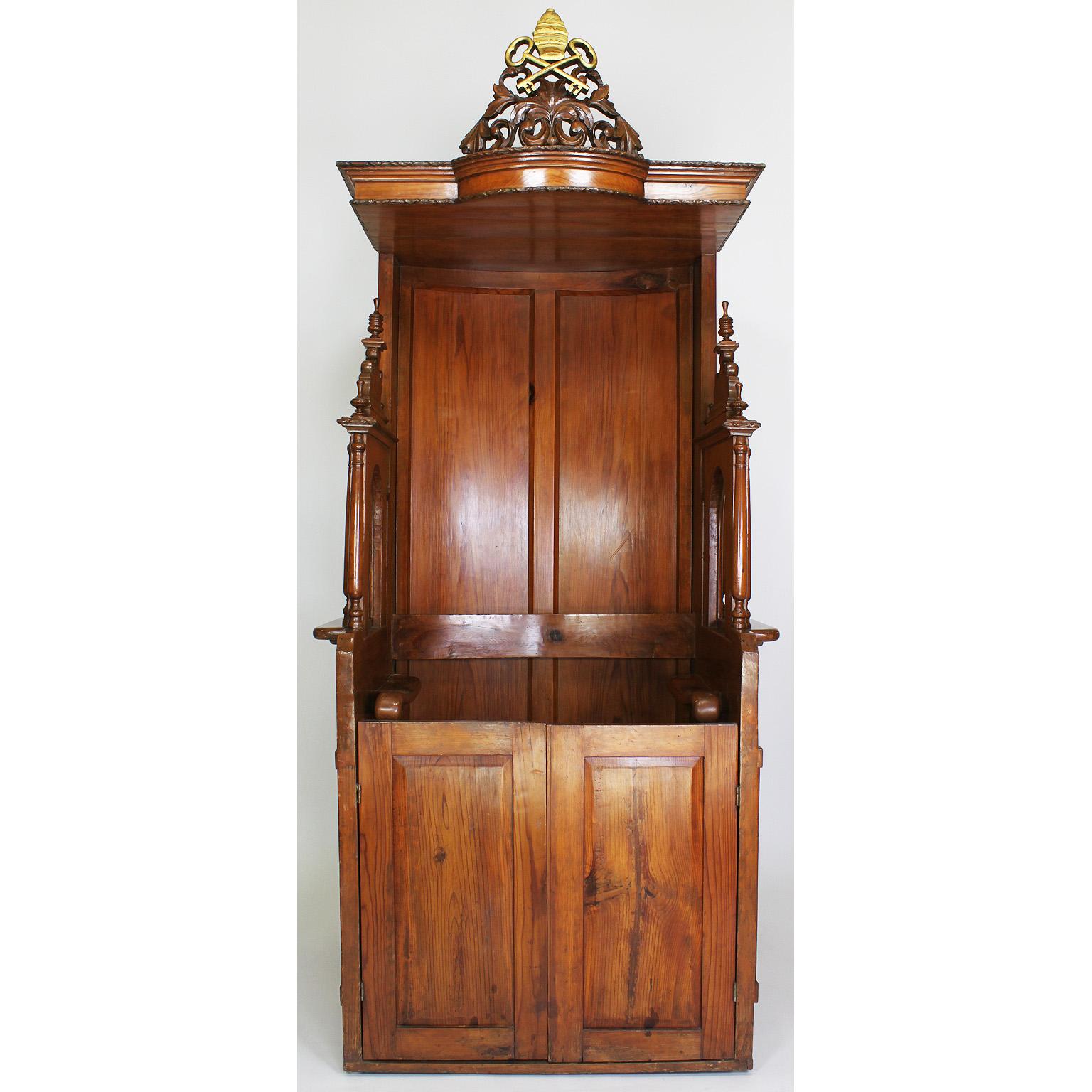 A rare Italian 19th century carved pine Catholic Church confessional stall, booth. The Baroque revival body crowned with a carved and parcel gilt Papal insignia, the official decoration for the Pope in his capacity as the head of the Roman Catholic