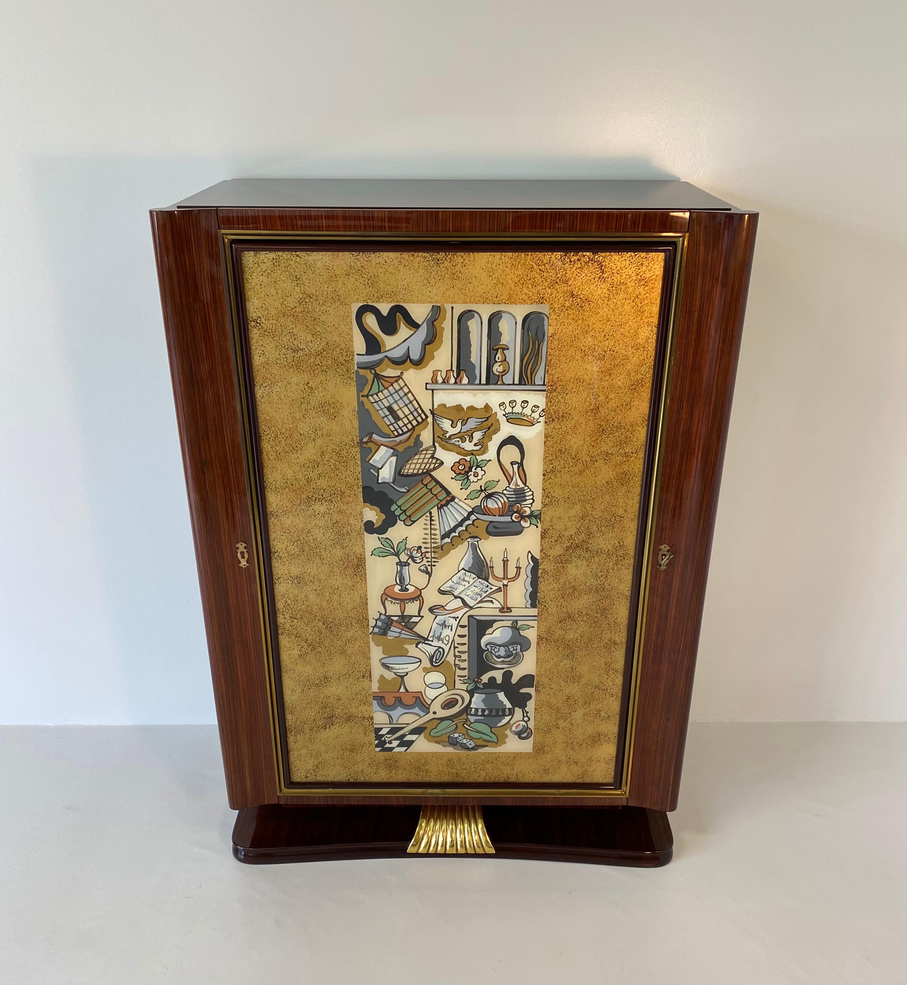 Rare bar cabinet made by the Dassi company during the 1950s.
The structure is in precious wood with gold leaf and eglomisè glass with typically Art Deco designs.
The interiors are in maple with copper and ivory lacquers.
The central door is also
