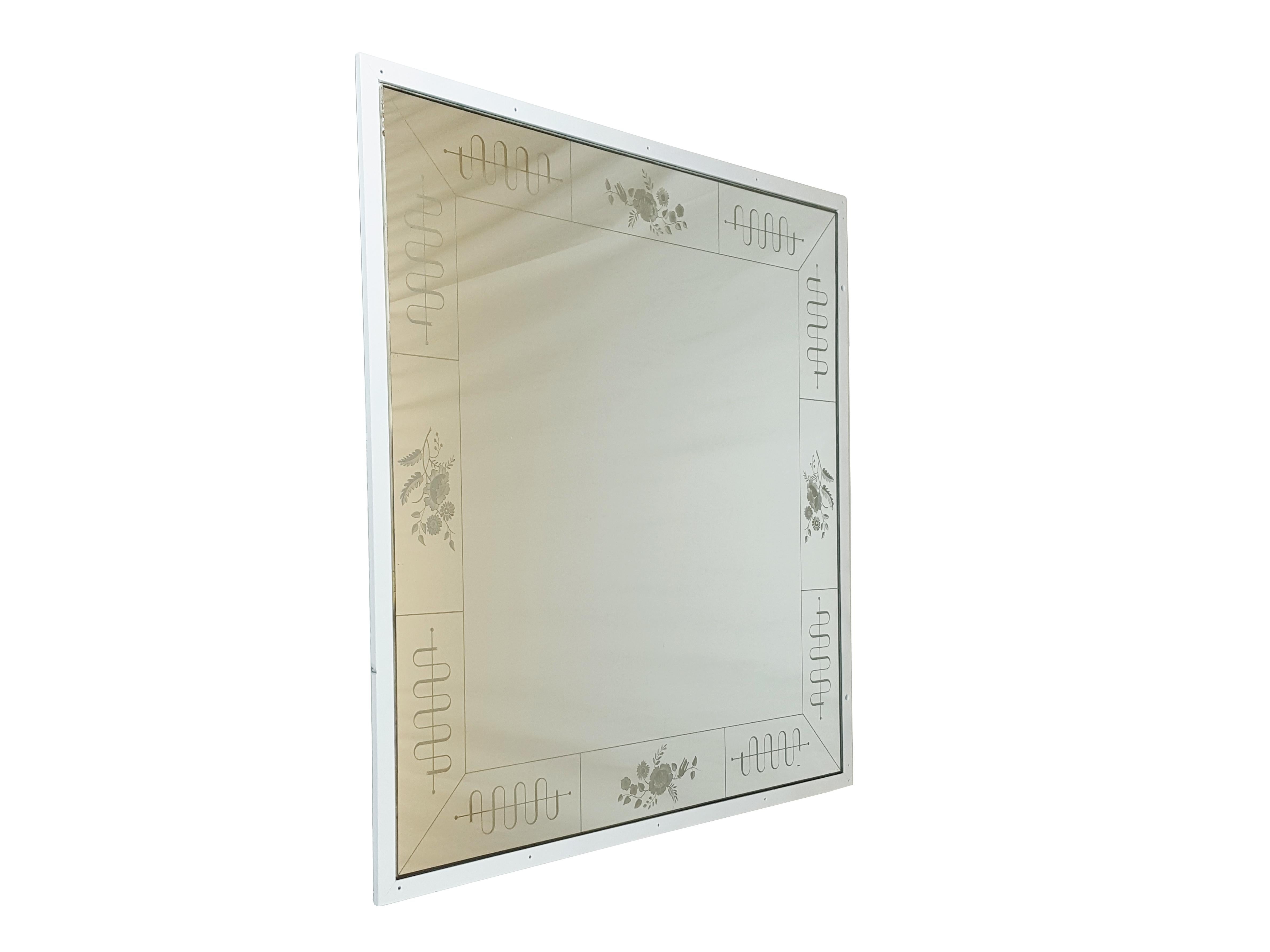 This amazing wall mirror was manufactured by the famous Italian Brusotti glassworks. It shows an elegant and precious frame decoration realized with the engraved glass technique. The mirror was designed to be fixed on the wall recessed, but it has