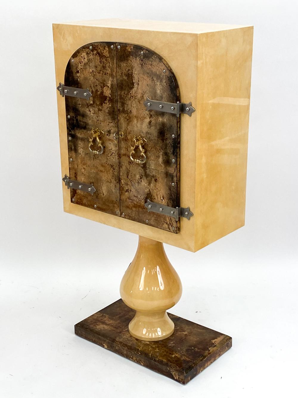 Ce meuble de bar unique a été conçu et fabriqué en Italie par Aldo Tura (1909-1963). Il est fabriqué en bois de haute qualité avec un placage en ronce, avec une finition brillante. La pièce est rehaussée de ferrures en laiton poli, et la porte avant