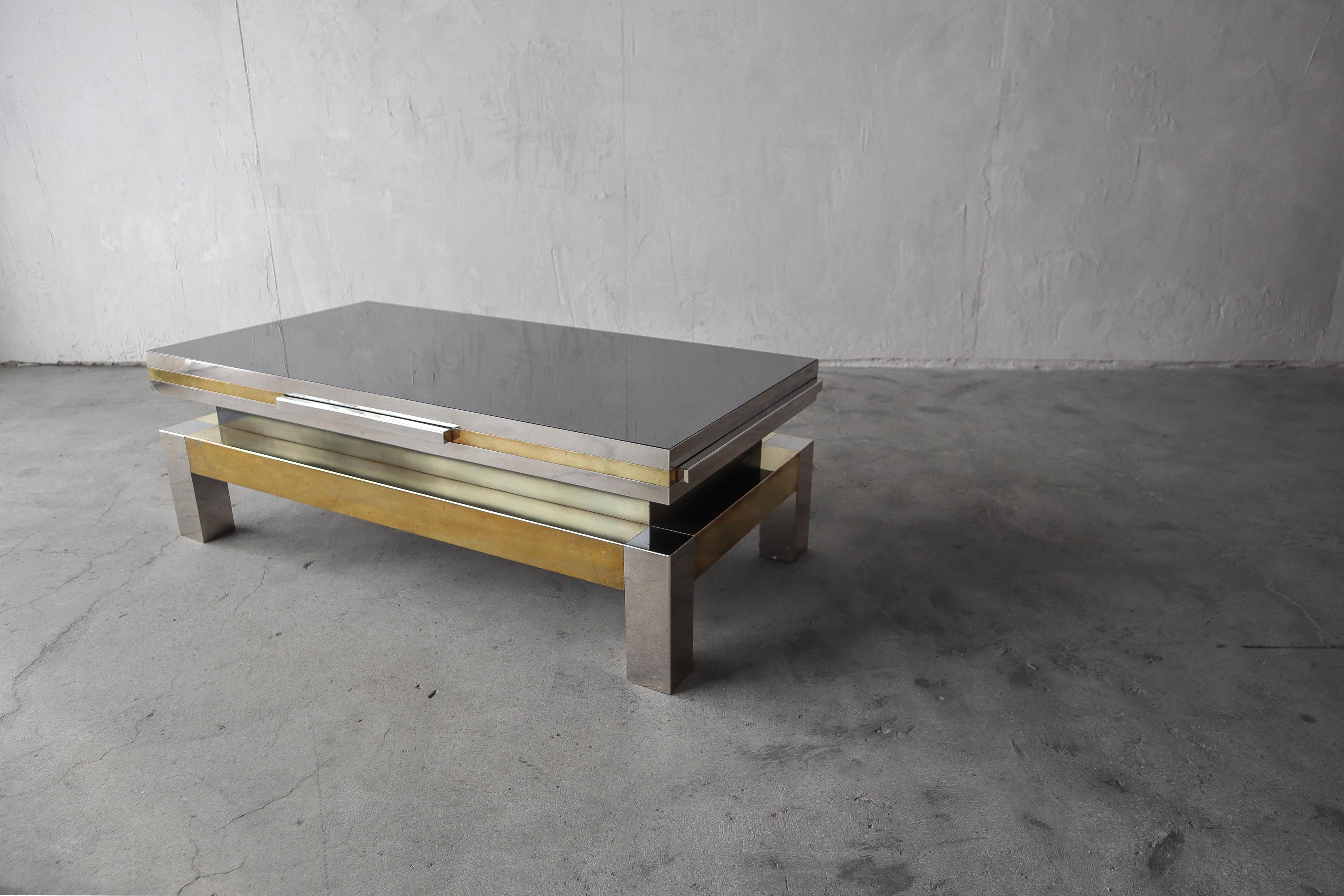 Rare Italian extension coffee table by Sando Petti. constructed out of chrome, brass and black glass this table is a stunning, unique piece, a true conversation table. Each side features a chrome pull out that widens and lengthens the table by