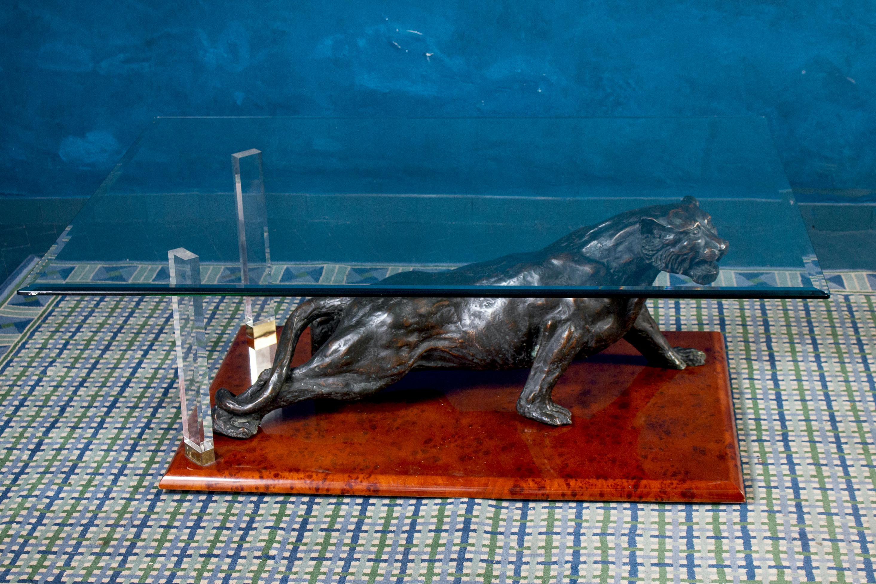Unusual and rare 1970s Italian coffee table with a black sculpture of panther on a wood base and a clear rectangular glass top.

