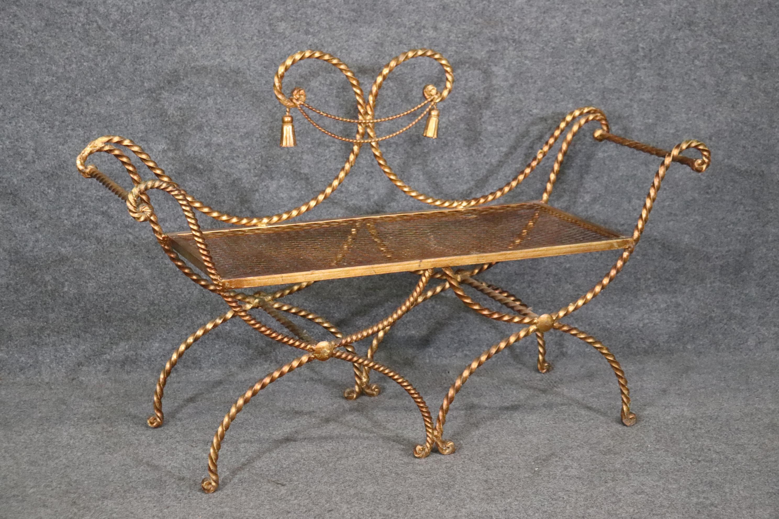 This is a dazzling gold leaf gilded wrought iron twisted rope and tassel designed window bench that's perfect for the window or even the end of a bed. The bench is in good condition and measures   30.75 tall x 48.75 wide x 16 deep and the seat