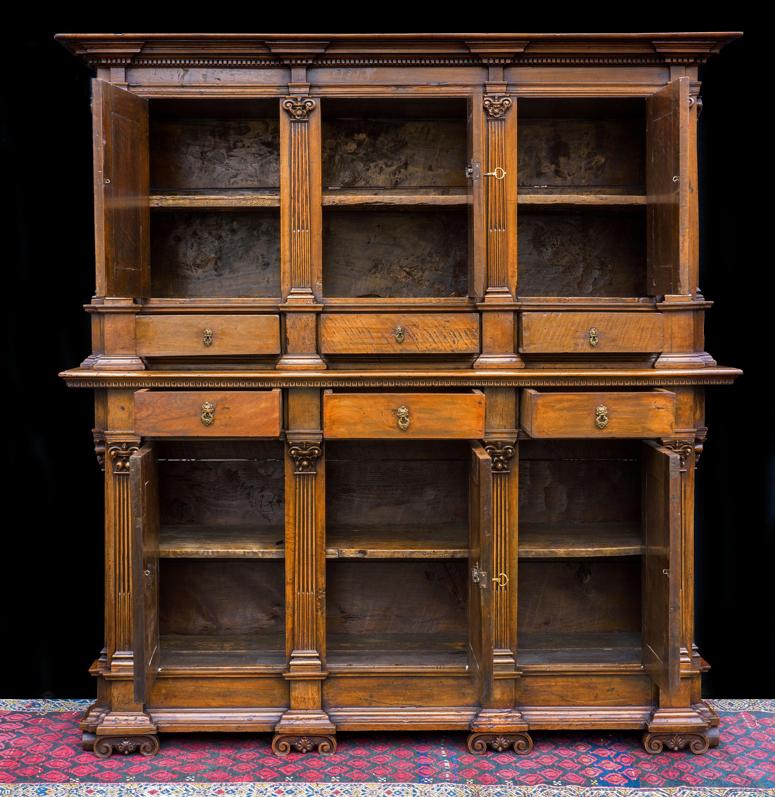 An exceptionally fine late Renaissance walnut cabinet from Tuscany. The two-part cabinet comprises an upper section of three cupboards concealing double shelves, and three drawers, divided by slender pilasters. The lower section is the inverse, and