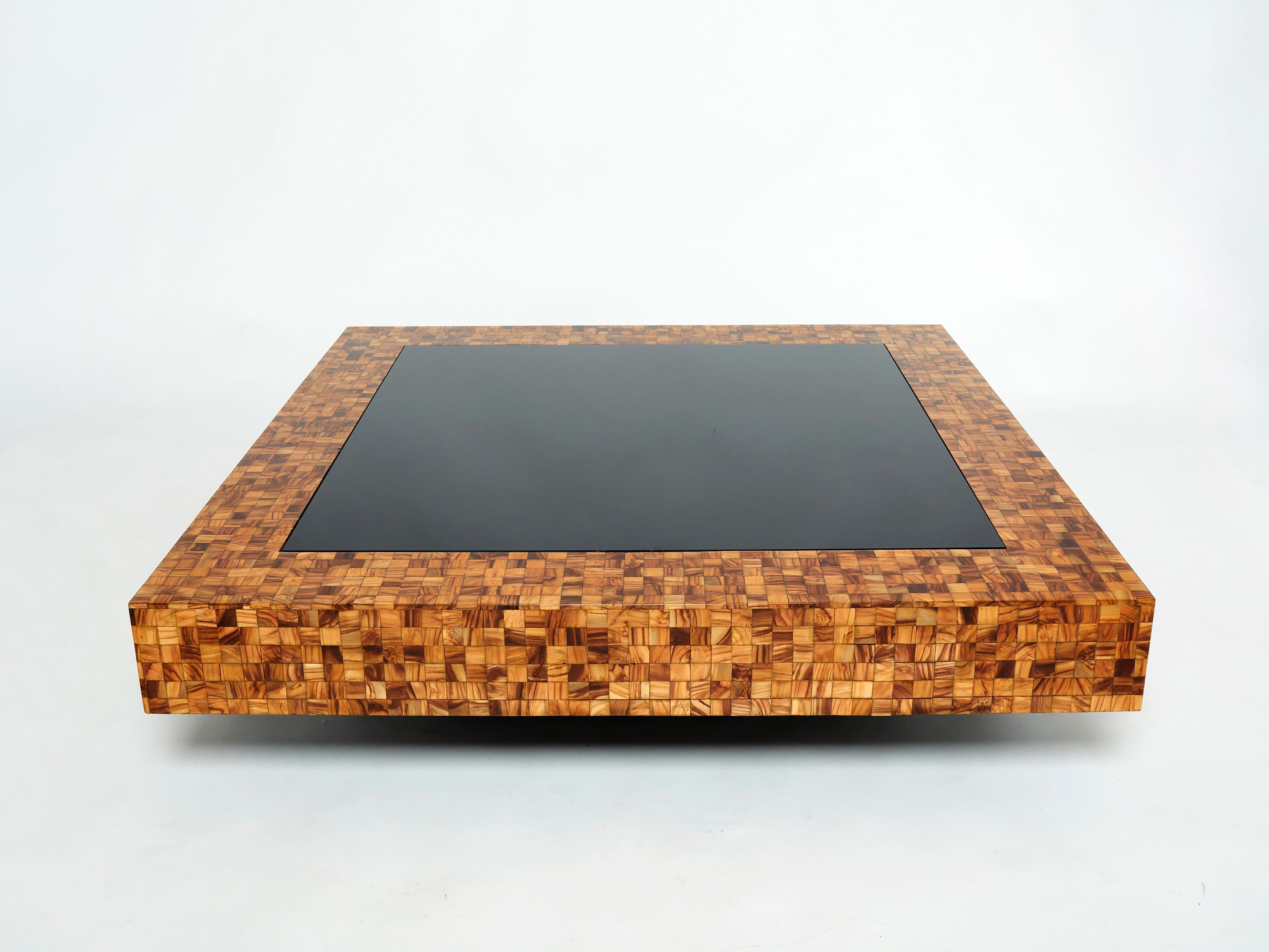 This beautiful square coffee table from the Mid-Century Modern French Riviera period is bursting with nostalgia. Designed by Sandro Petti for l’Angolometallarte Roma, it features a light golden and brown olive wood marquetry frame, with a black