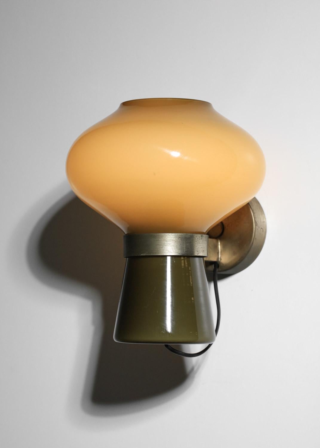 Raro aplique de pared creado en 1954 por el diseñador italiano Massimo Vignelli para Venini, modelo 4040. Estructura metálica y doble pantalla de cristal de Murano color caqui. Muy buen estado vintage, con ligeros arañazos en el cristal y restos de