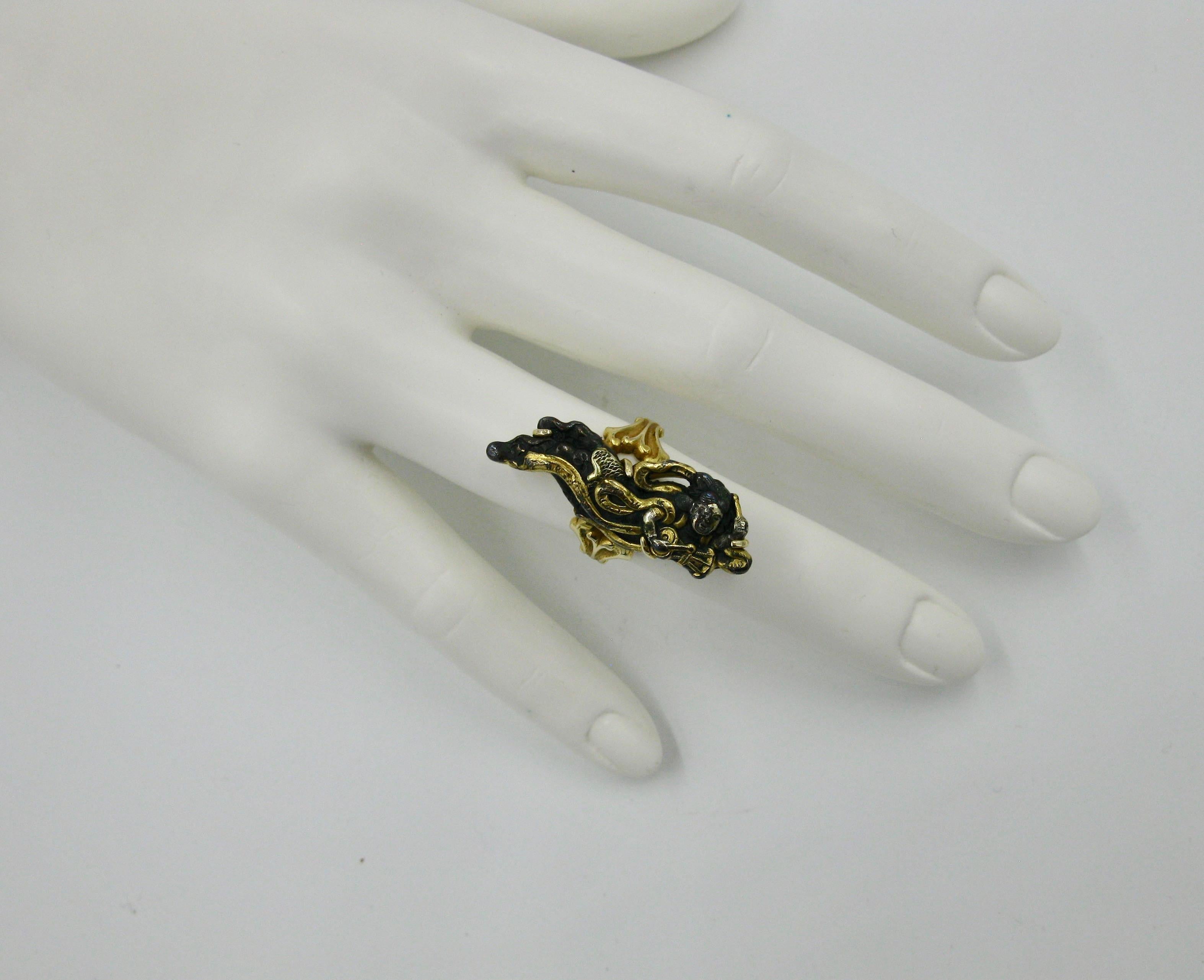 A very rare ring depicting a woman in flowing robes playing a musical instrument in the historic Japanese art form of Shakudo, in 14 Karat Gold.   The Shakudo pieces originated in the Samurai period in Japan and were created by esteemed artists who