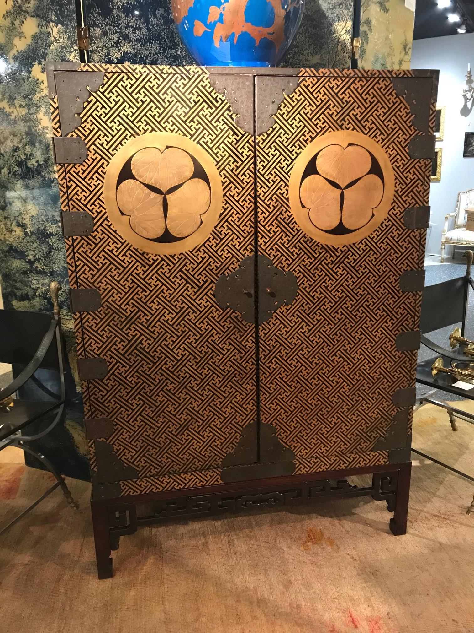 Rare lacquered wood two-door cabinet beautifully decorated with gold “hiramaki” decoration on a black lacquered geometric pattern bearing the Tokugawa family crest. Fitted with engraved iron hinges and mounts and the interior includes five drawers