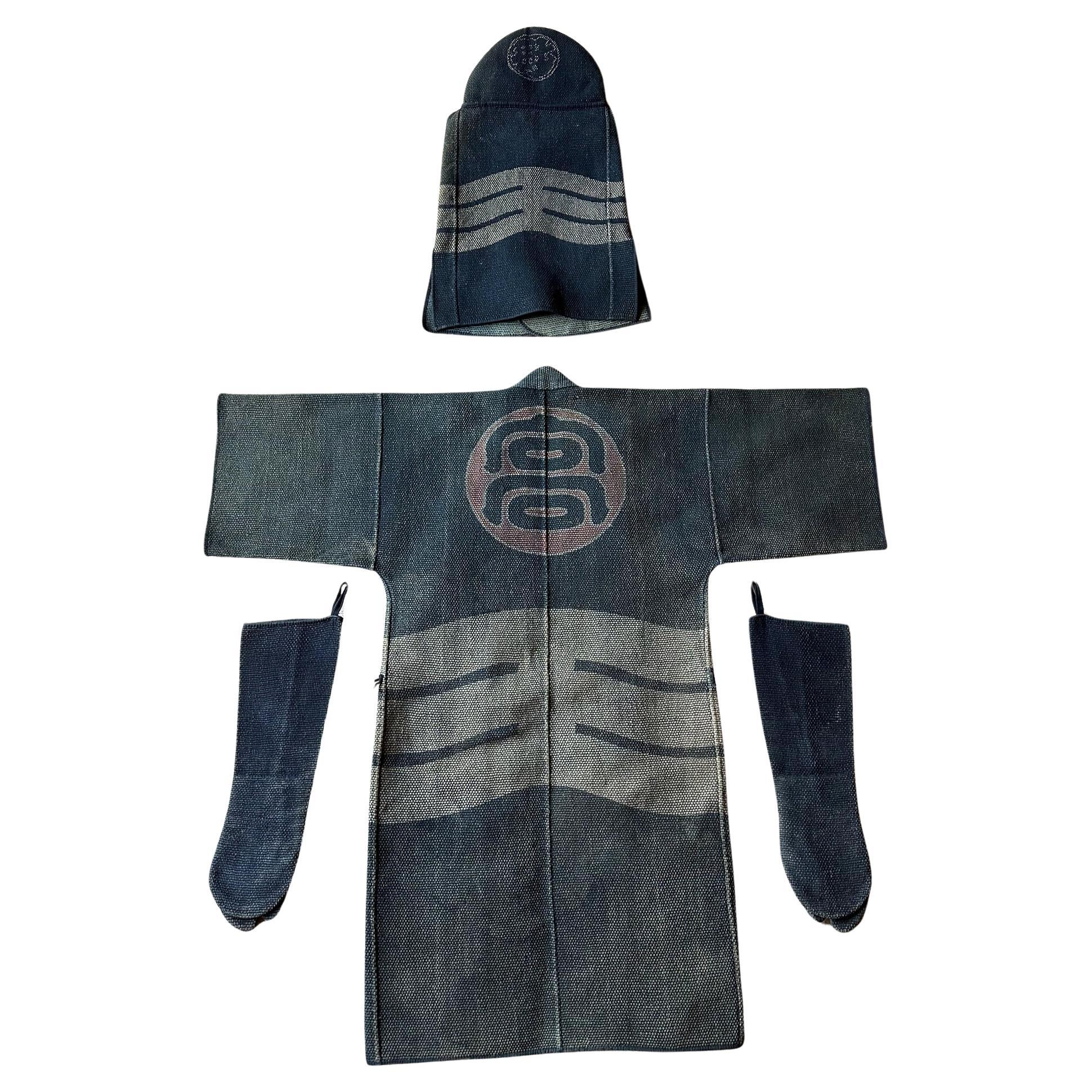 A rare four-piece Japanese Fireman's assemble (Shobosho uniform) woven with heavy cotton and decorated with stencil resist dye circa 1890-20s Late Meiji to Showa Period. The assemble consists of a long jacket (Hikeshi-Haten), a heavy-padded hooded