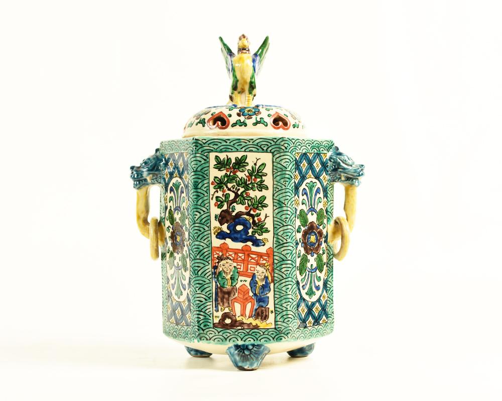 A large, rare and colourful Japanese hexagonal Aode style Kutani pottery incense burner with tripod legs and a splendid phoenix finial, wing outstretched, complete with yellow, teal and blue sweeping tail feathers and dragon head handles. It is