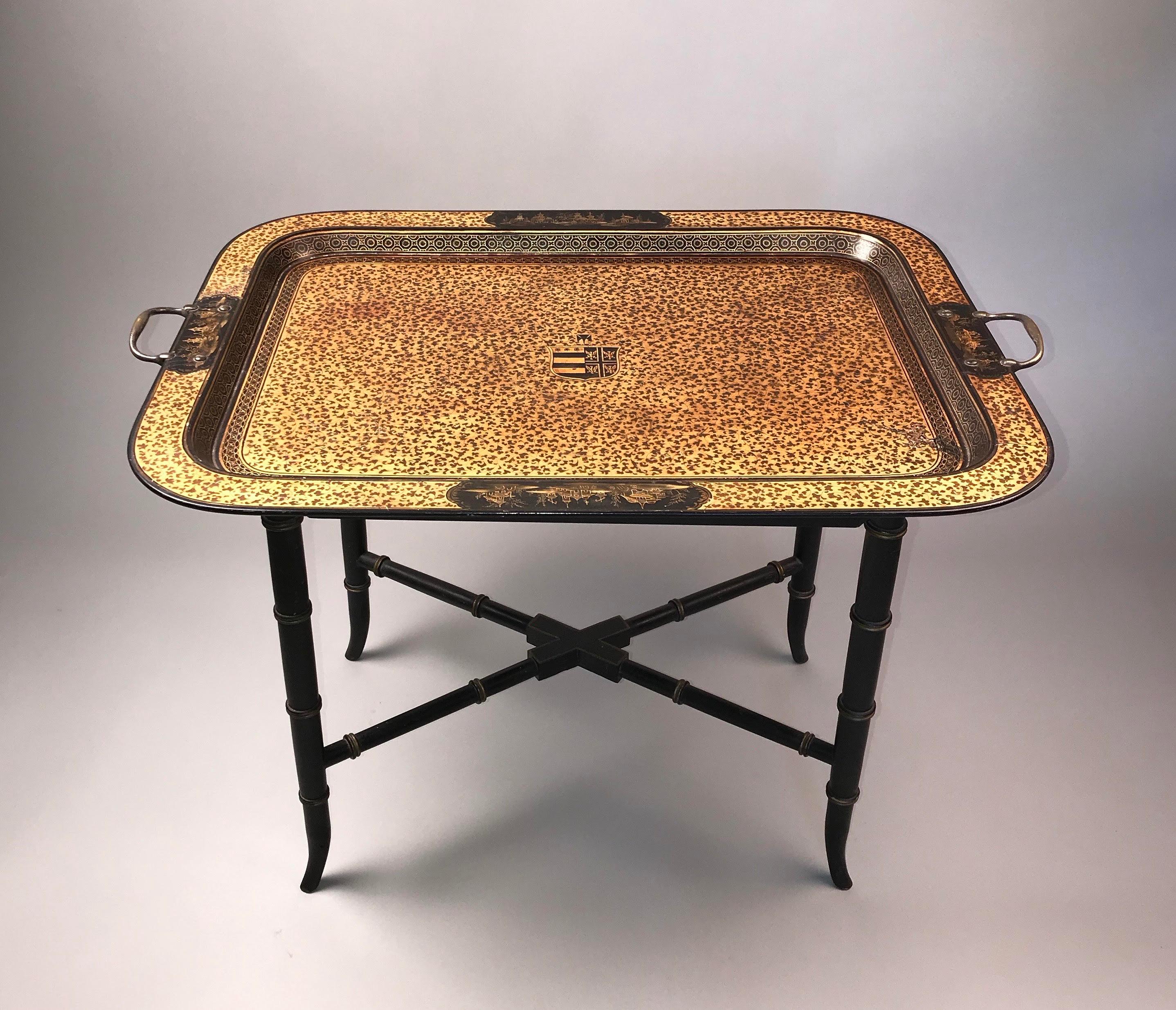 A rare English Regency period japanned tray table. 
Early 19th century, circa 1810.

The dished top exquisitely decorated overall with complex floral designs in gilt, and unusually centered by an armorial. The raised borders have very finely