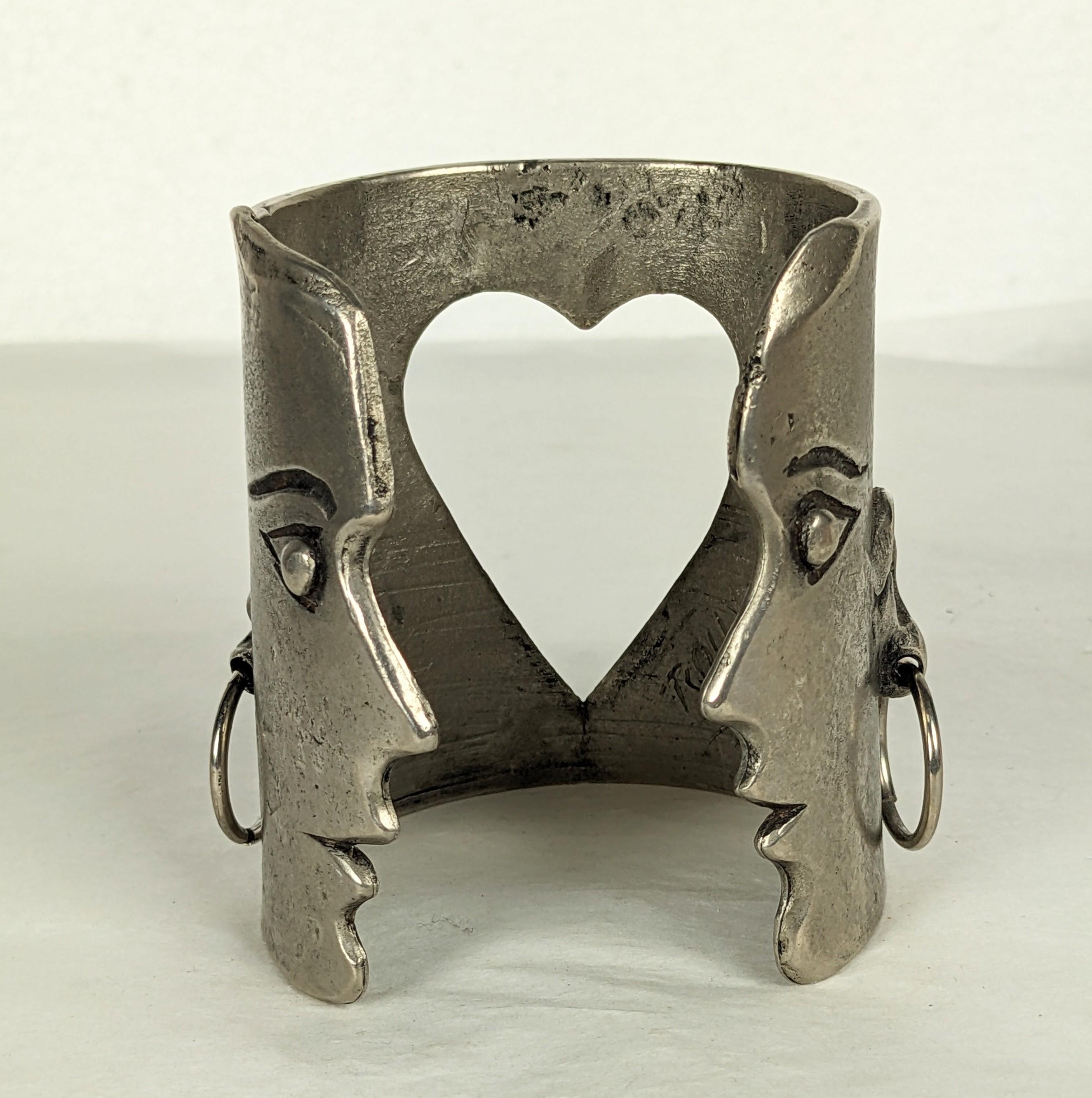 Rare Jean Charles de Castelbajac Figural Runway Cuff from the 1980's. Patinaed silvered metal created by D. Roux for Castelbajac. A double headed face motif with dangle hoop earrings and central heart cutout. 2.75 wide, length 6.5