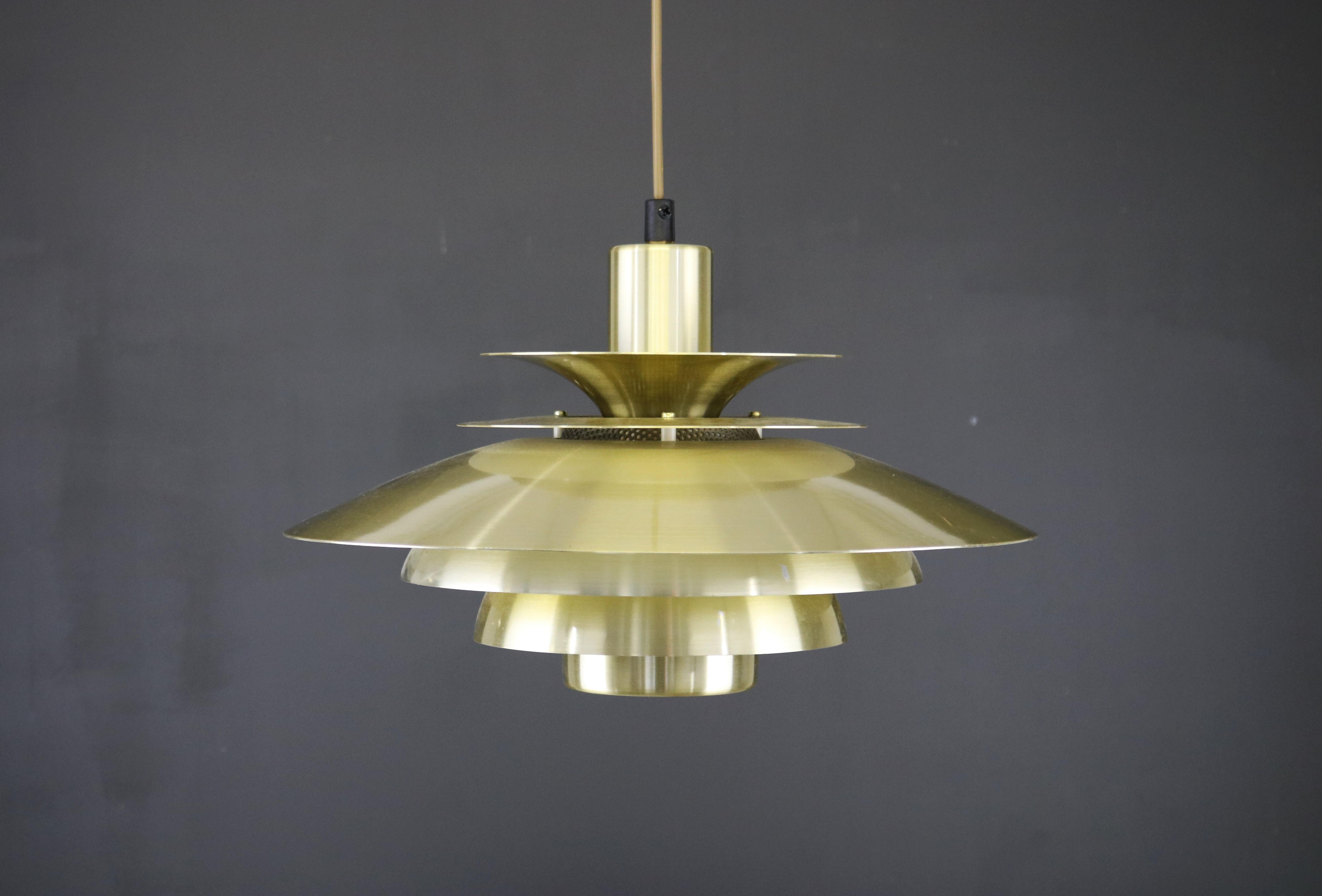 JEKA Lampe suspendue danoise dans une chaude couleur dorée. Ce modèle, 