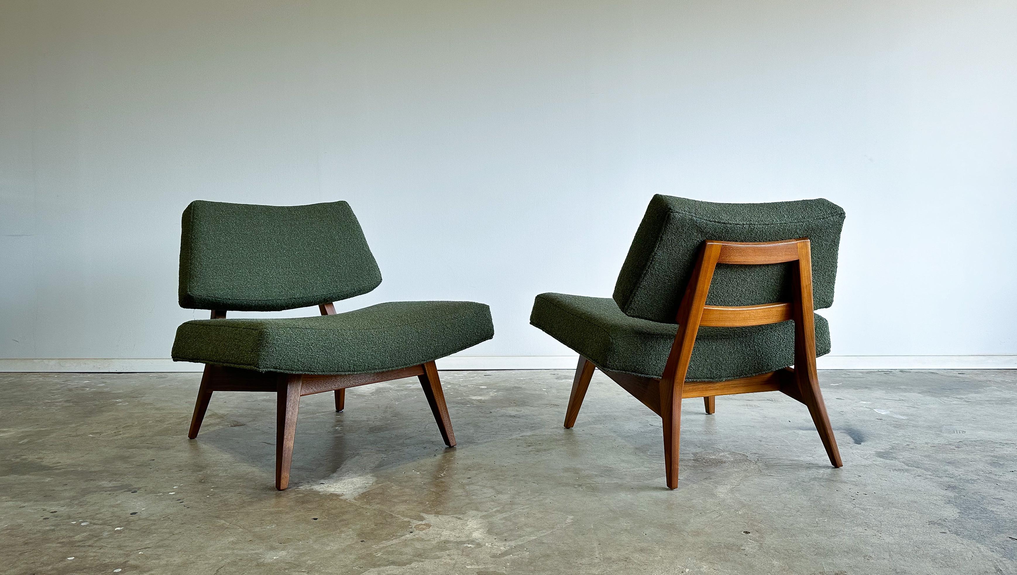Offered is a rare pair of low lounge chairs designed by Jens Risom for Risom Designs, Inc. circa 1952.

Low, deep, and wide these chairs have an amazing presence and level of comfort. Featuring fully restored sculpted solid walnut frames paired with