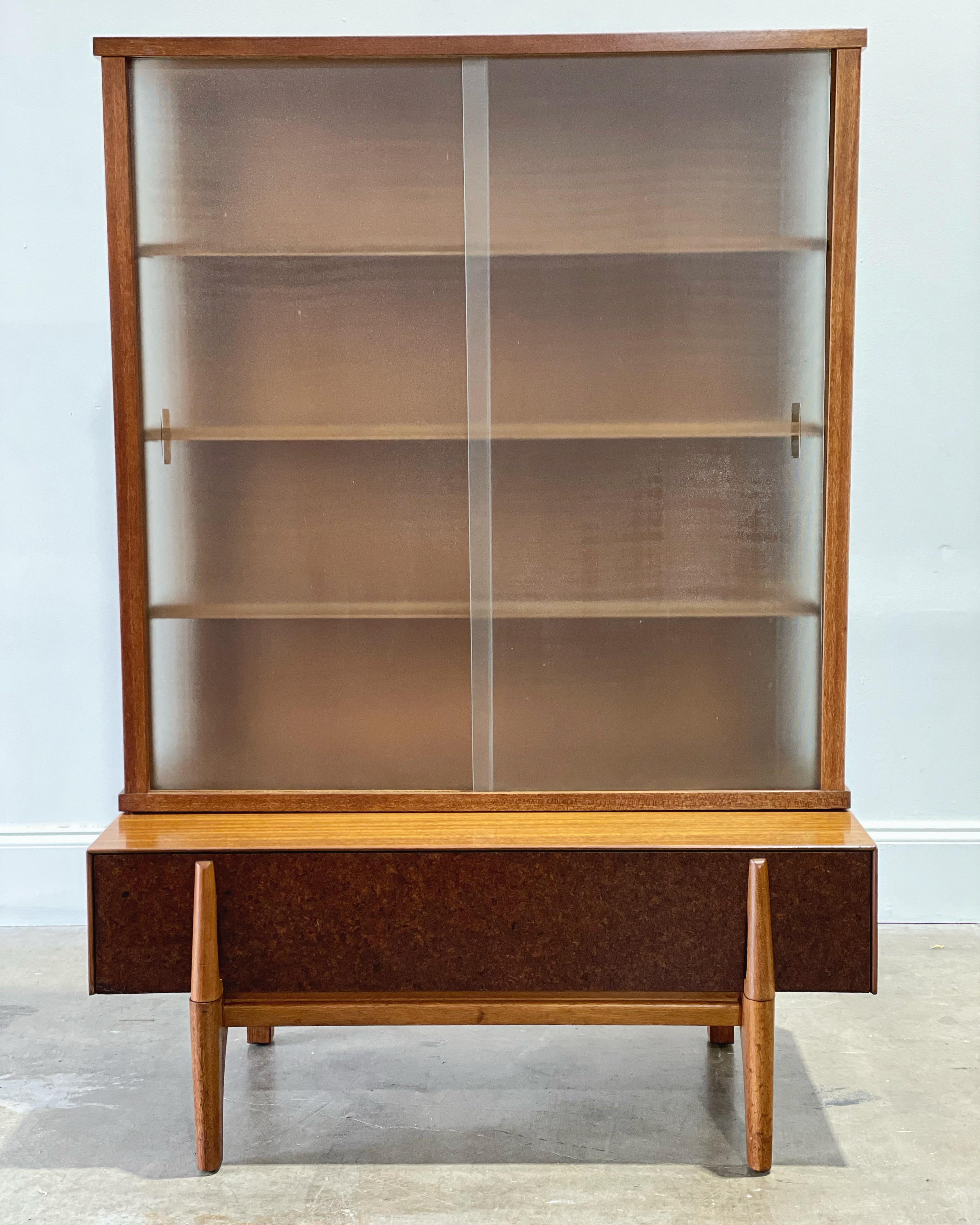 Scarce Mid-Century Modern vitrine display cabinet designed by John Keal for Brown Saltman, circa 1952. Mahogany and micro-screen textured glass. This unit consists of two pieces - the lower base, consisting of one large drawer integrated with the