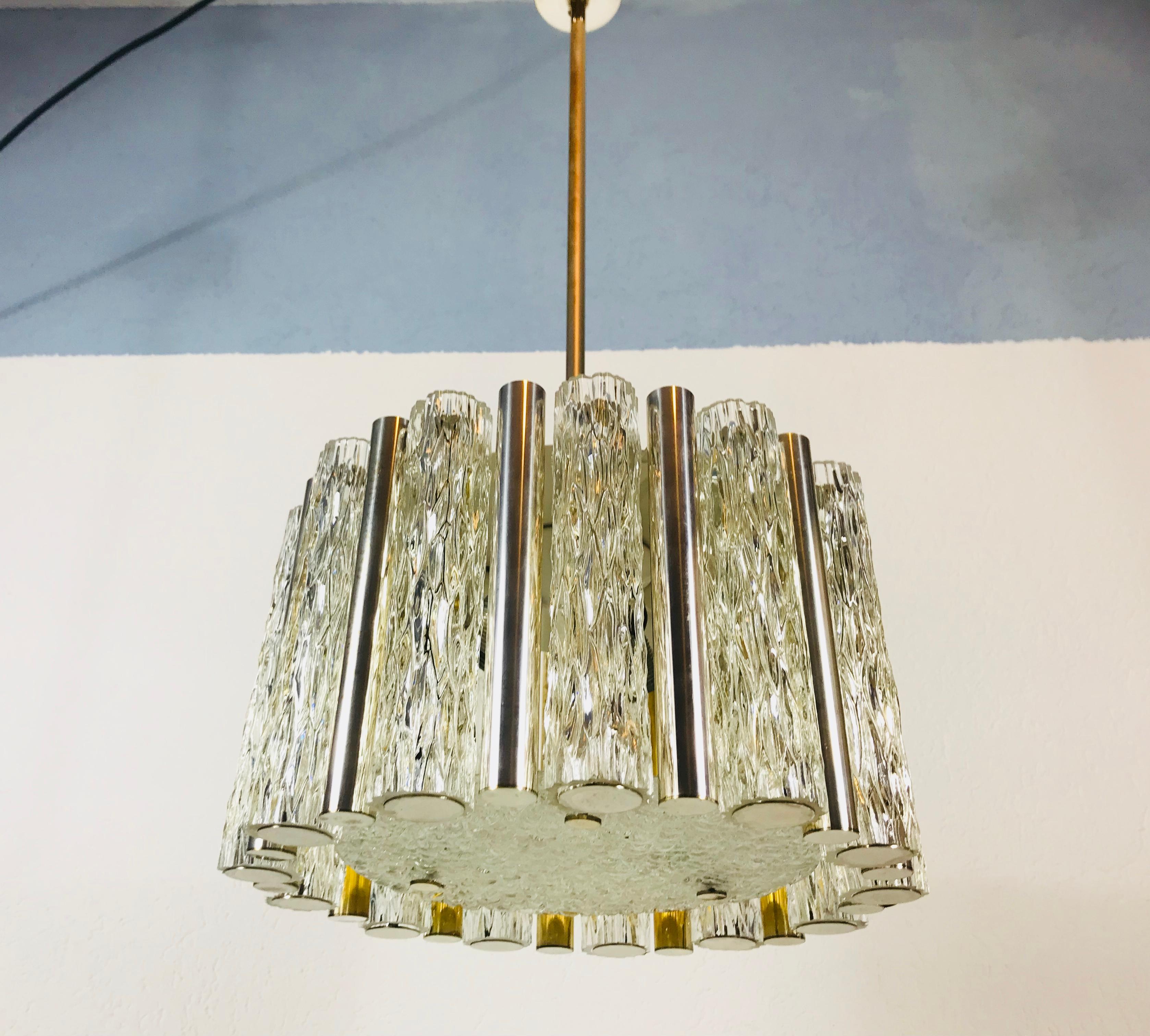 A Kaiser Leuchten ice glass chandelier made in Germany in the 1960s. It is fascinating with its rare tube glass shapes. A circular ice glass body on the bottom with 13 frosted glass tubes and 13 polished aluminium tubes. It has a very long brass