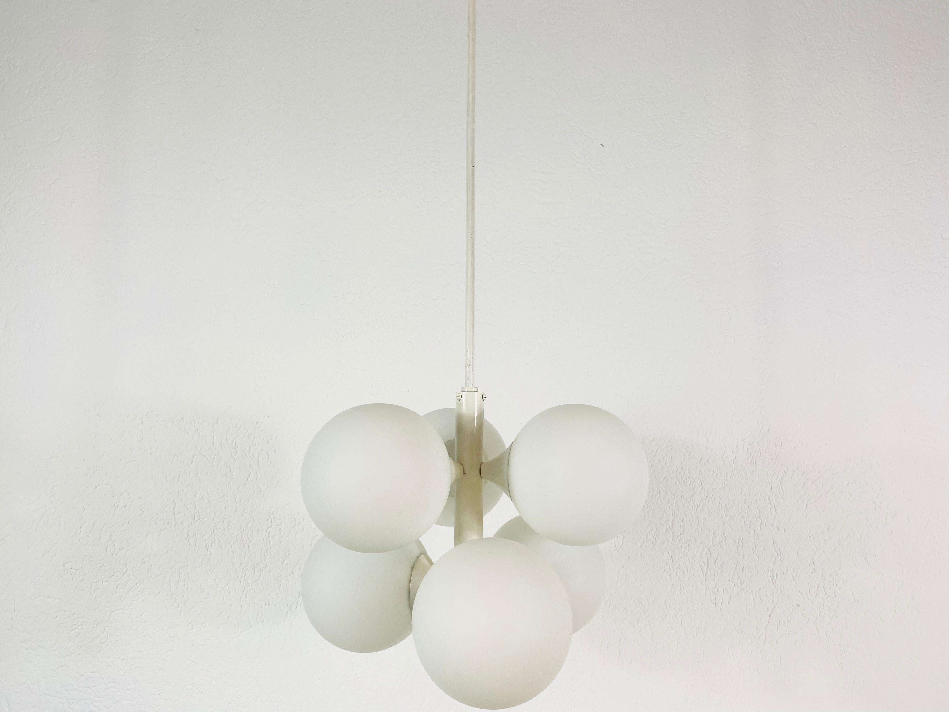 A midcentury chandelier by Kaiser made in Germany in the 1960s. It is fascinating with its Space Age design and four opaque balls. The white circular body of the light is made of full metal, including the arms. White bar with white canopy.


The