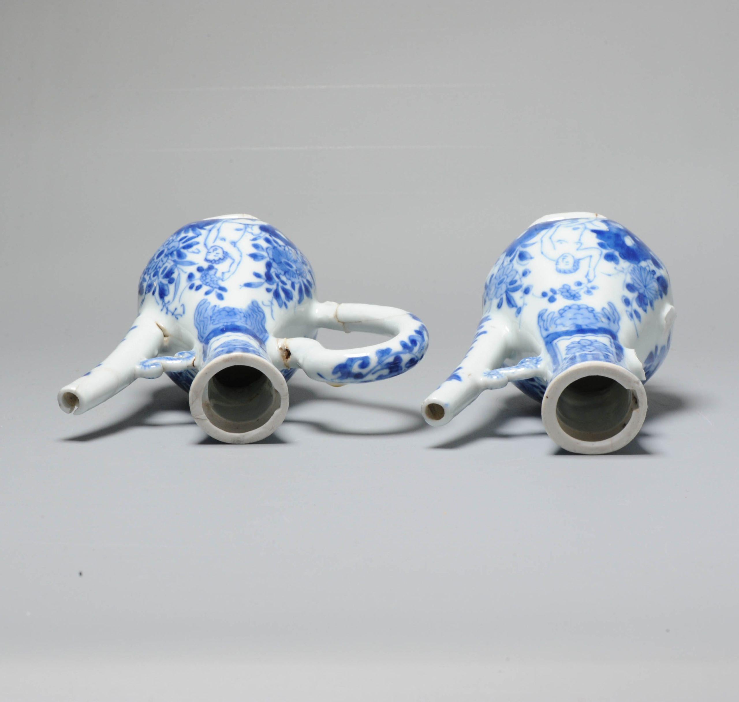 The lovely, nice quality and very unusual pair of 2 blue and white octagonal pear-shaped ewers, Kangxi period. Both have two naked figures in a garden scene seated on rocks amongst flowers, one holding a scythe, the other a flower spray. They would