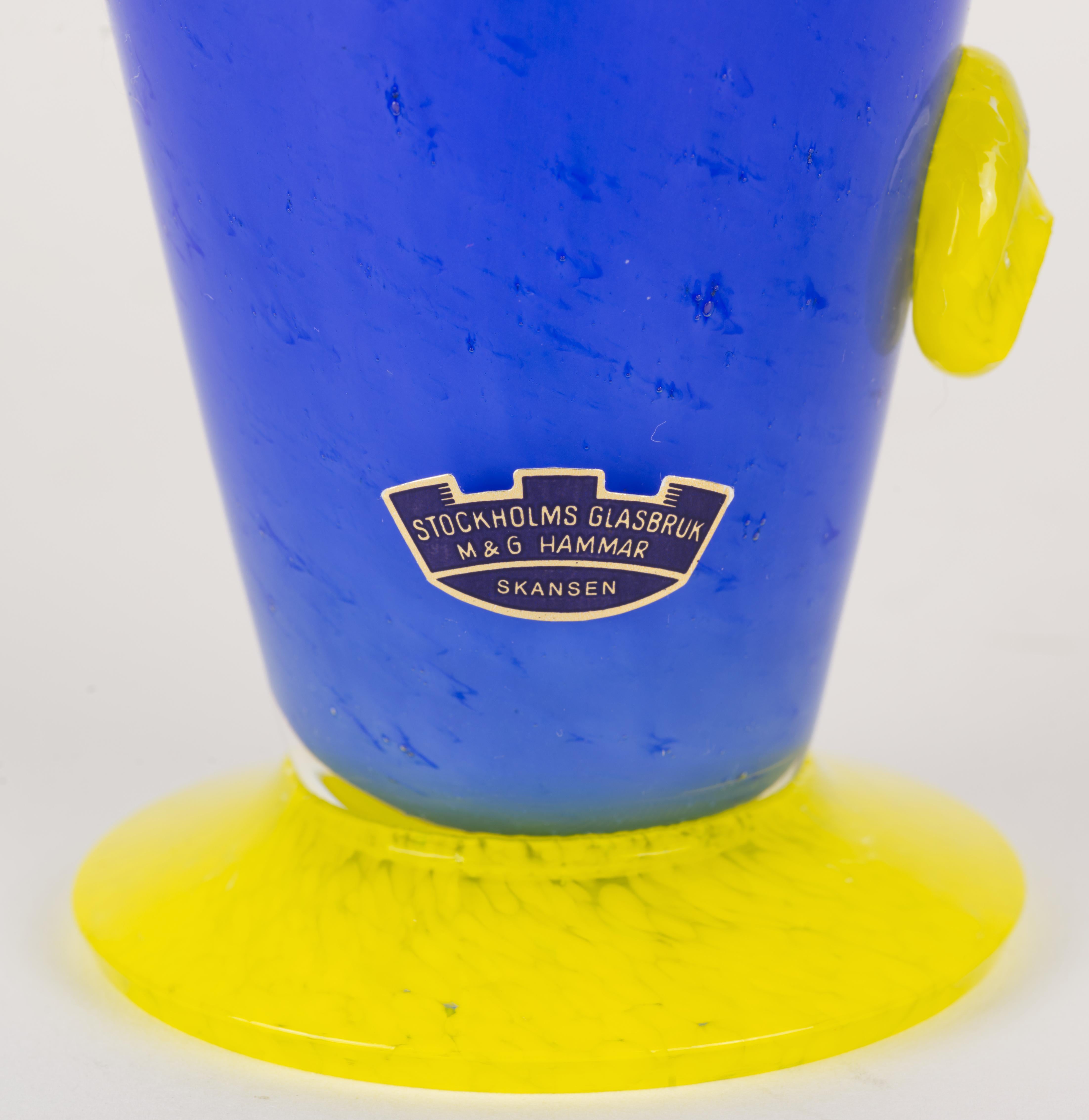  Il sorprendente vaso in vetro artistico The Modern Scandinavian è stato disegnato da Karin Hammar e soffiato a mano da Stockholms Glasbruk. Il corpo grafico e geometrico del vaso è stato realizzato in vetro blu con inclusioni di pigmento blu scuro