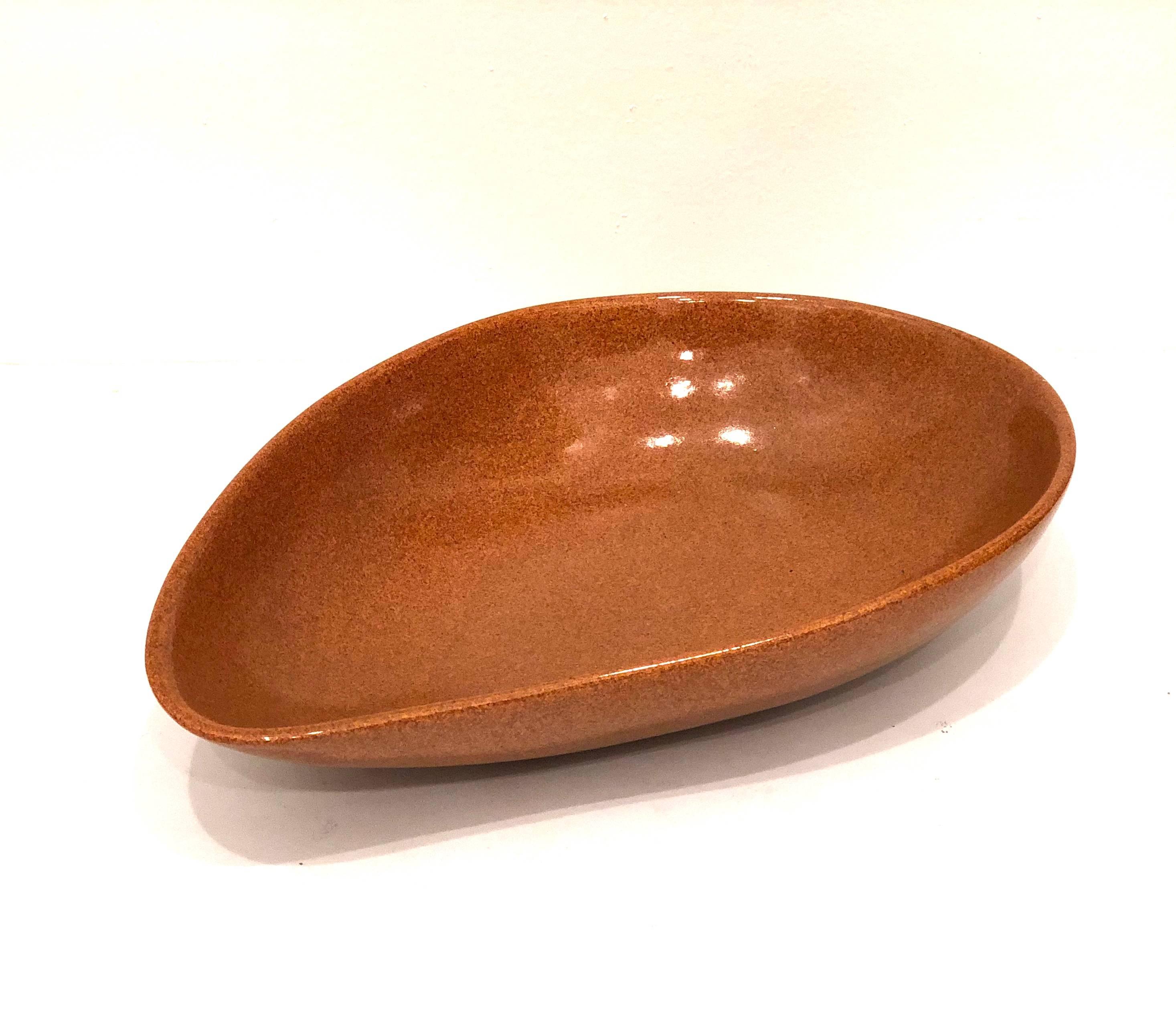 Large and unique kidney shape ceramic bowl signed by San Diego artist Barney Reid, circa 1960s in a terracotta, orange ,brownish color with a glaze finish excellent condition no chips or cracks, his pieces are very rare and highly collectible.