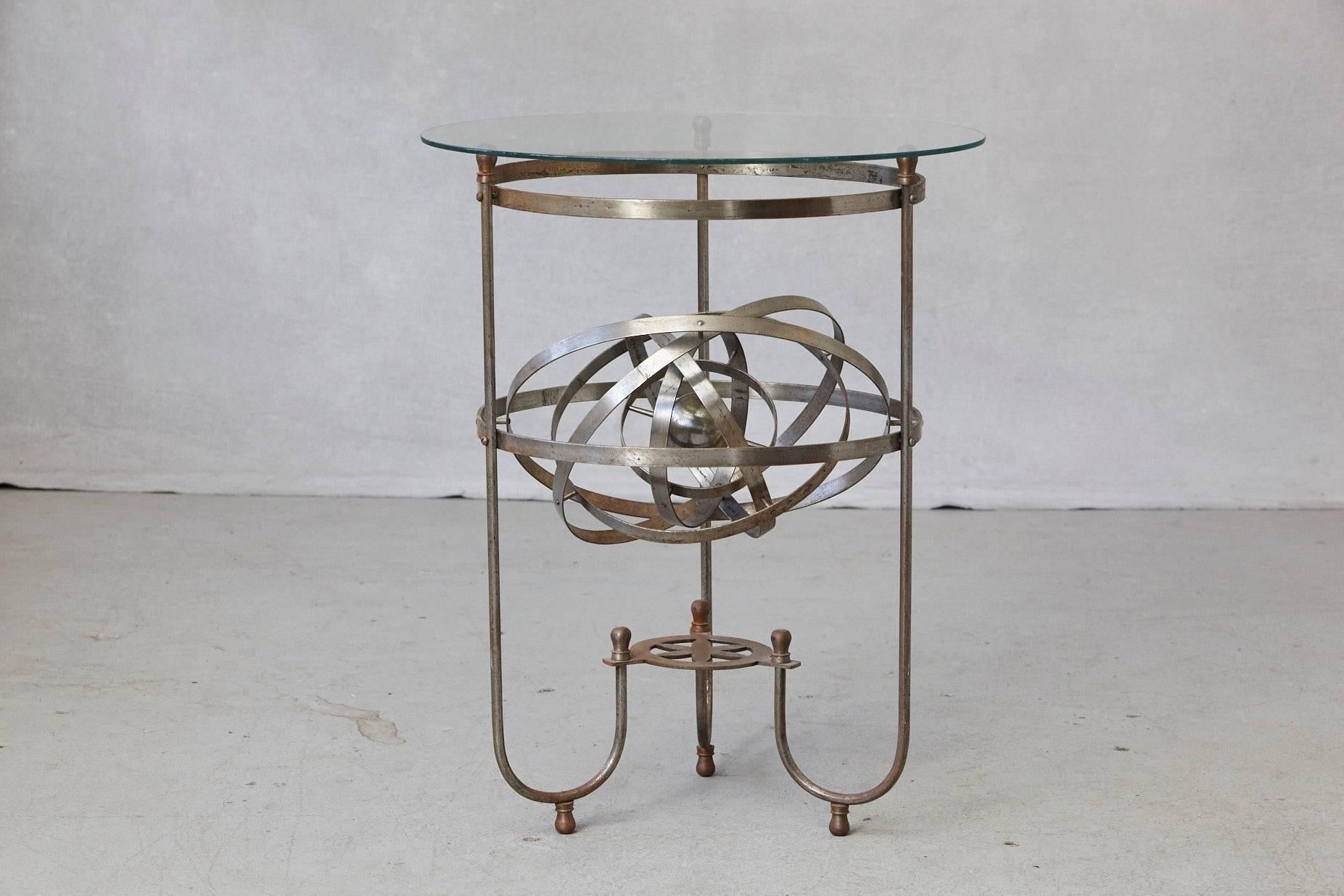 Rare and exceptional kinetic side table with revolving orbital motion, England, 1930s.
Steel base with a perpetual revolving orbit within the table and glass top.
The inner iron ball has an engraving - Sweet Sound Steel Boom.
The table has a
