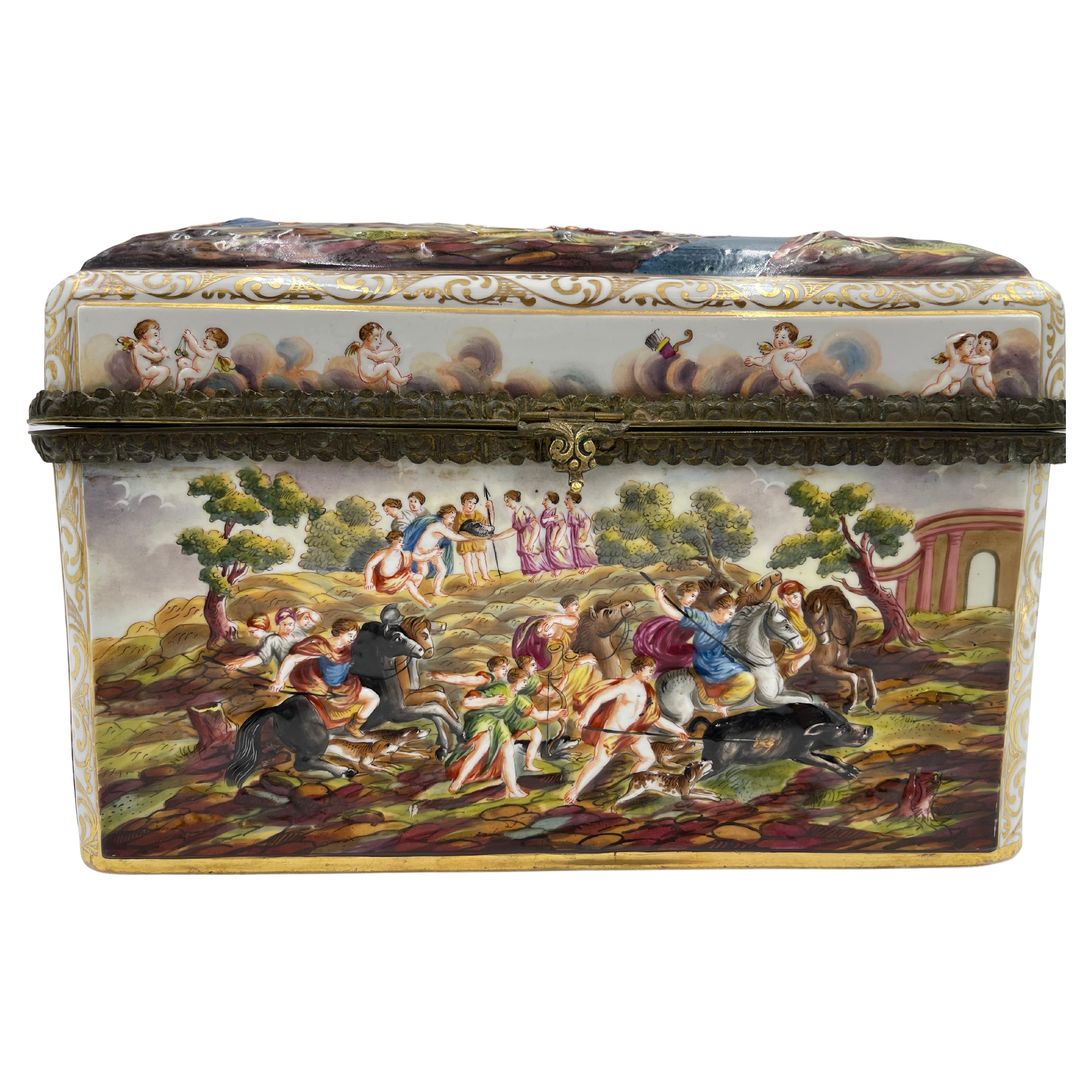 Spectacular large Capodimonte porcelain table casket/box, late 19th, and decorated with polychrome and gilt relief molded panels decorated with mythological scenes. Ormolu/gilt metal mounts. Crowned 