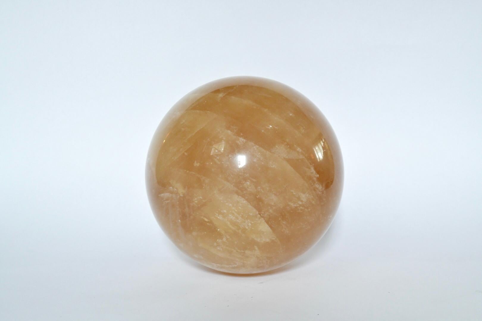 Rare, large translucent amber rock crystal ball with beautiful veins.