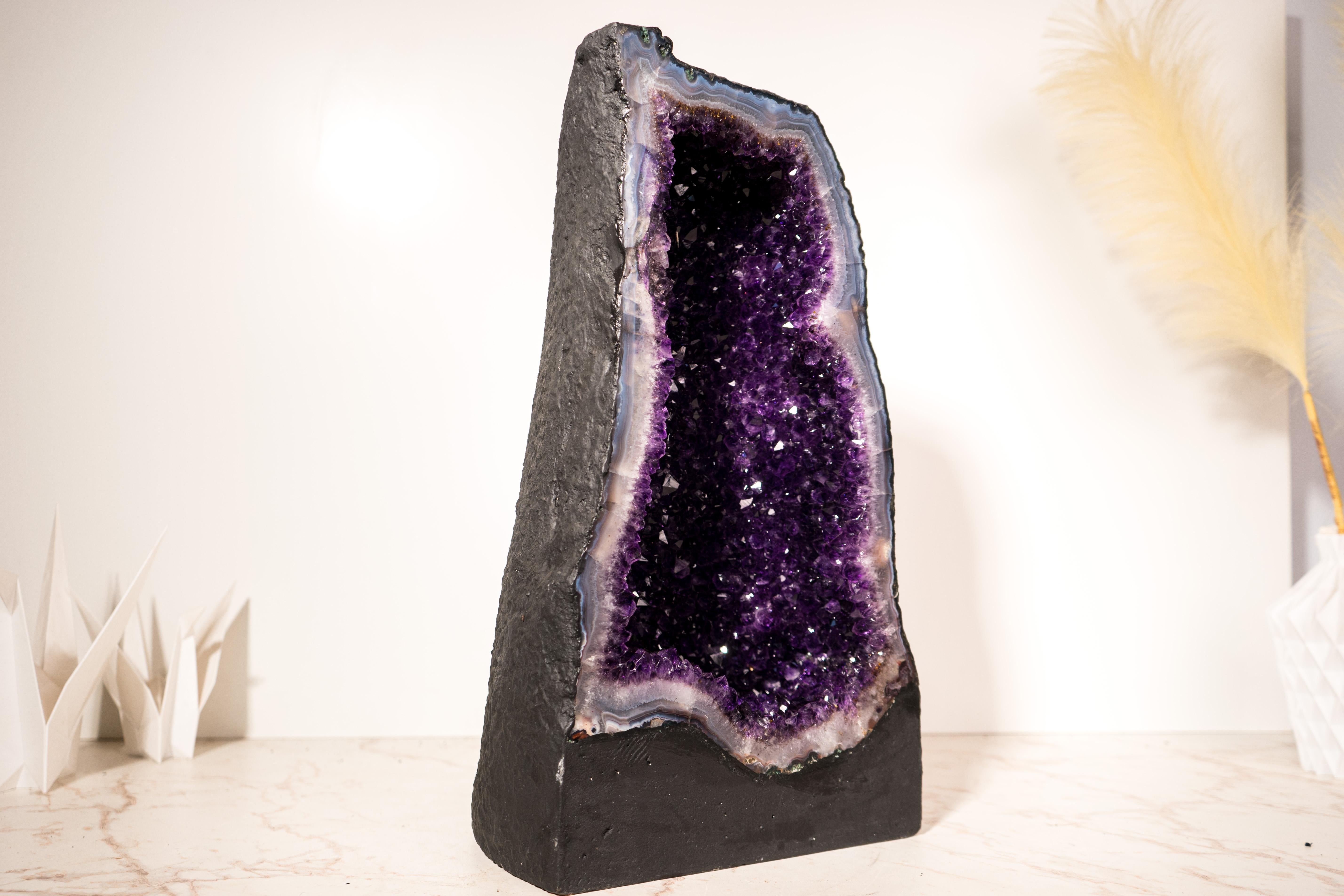 A Brazilian Geode Cathedral with prettier Violet Purple Amethyst Druzy and a Sky-Blue Lace Agate Frame

▫️ Description

The best amethyst color is one that is neither too dark—making it hard to see—nor too light, which can diminish its beauty. This