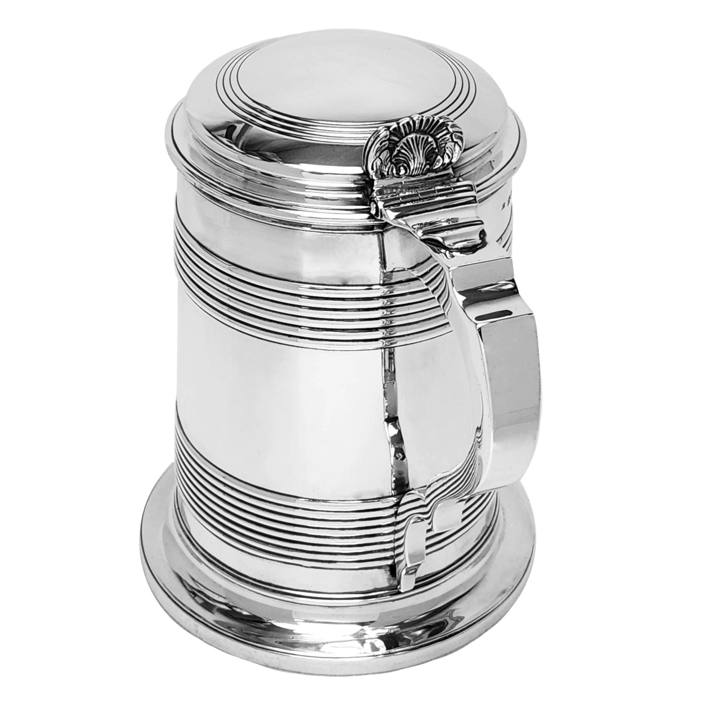 A Rare Large Antique George III Solid Silver Lidded Tankard in a classic straight sided shape and embellished with an elegant, understated reeded band design. The Tankard has a domed lid with a complementary reeded design and a shell thumb piece.