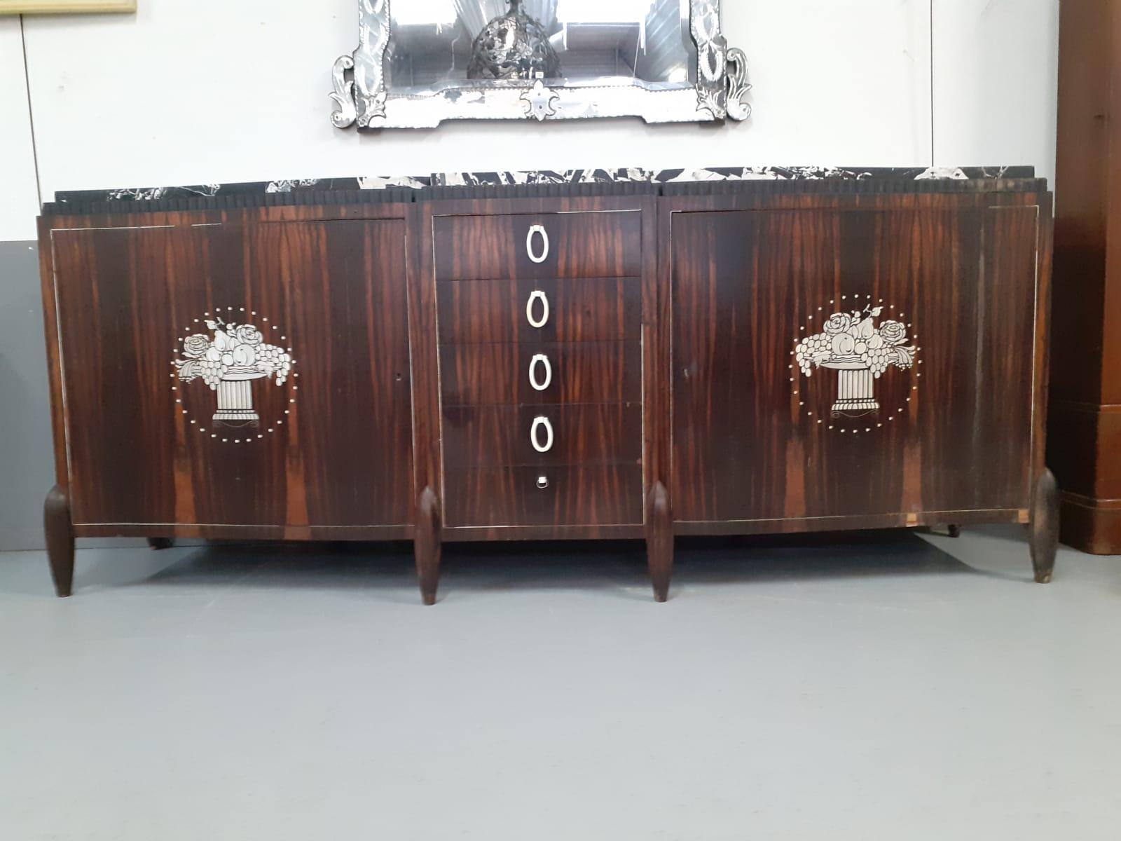rare large Art Deco sideboard in macassar ebony veneer circa 1925.
handles and decoration in ivory.
top covered with a marble.
good condition ,
missing a handle (which will be reproduced)
small gaps in the decor.
  