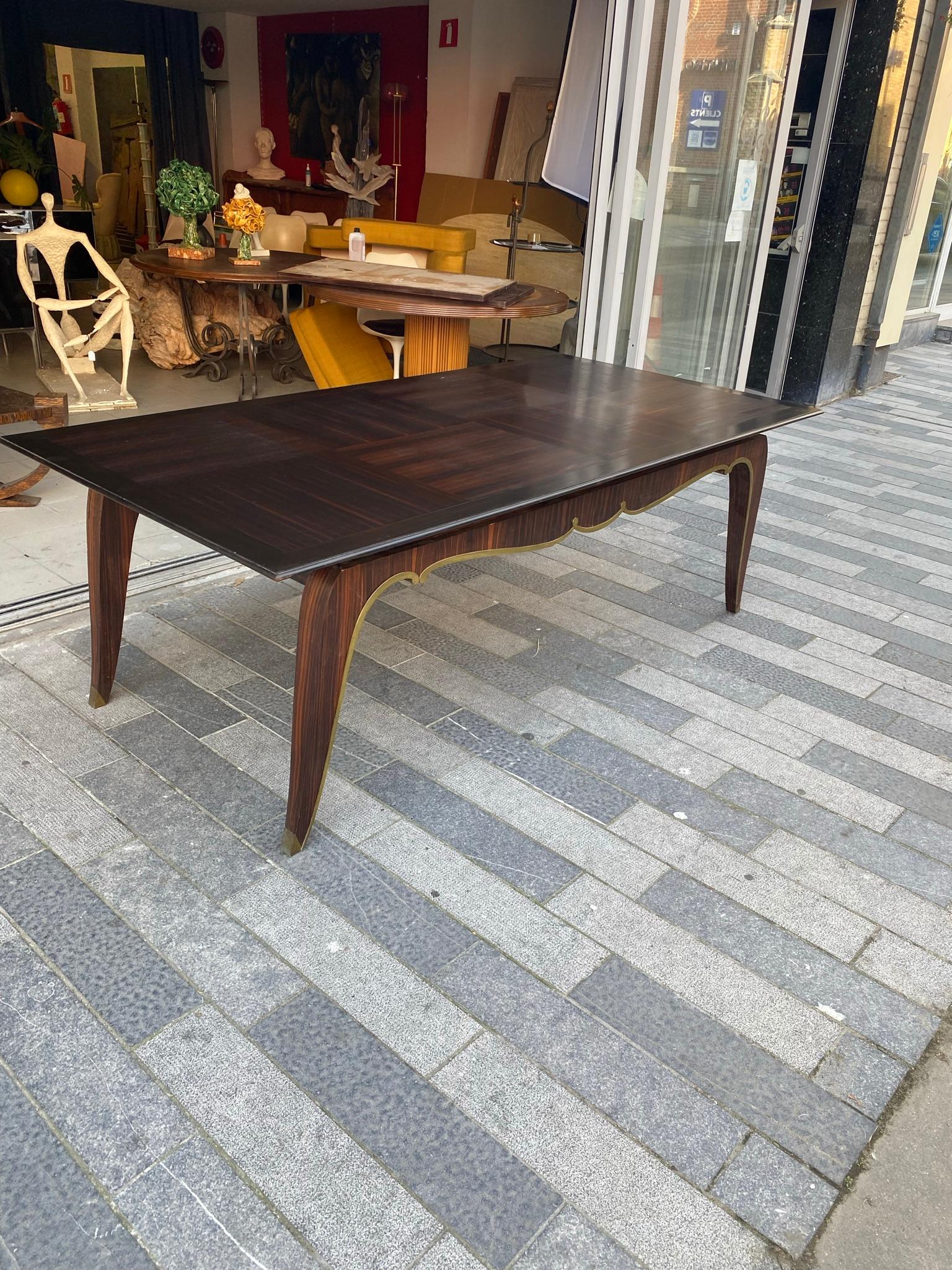 Rare grande table Art Déco en ébène de Macassar et bronze vers 1930 
très beau placage avec de petits défauts, le vernis de la table doit être refait 
Dimension : 74 x 220 x 110 cm
74 x 320 x 110 cm avec extension.