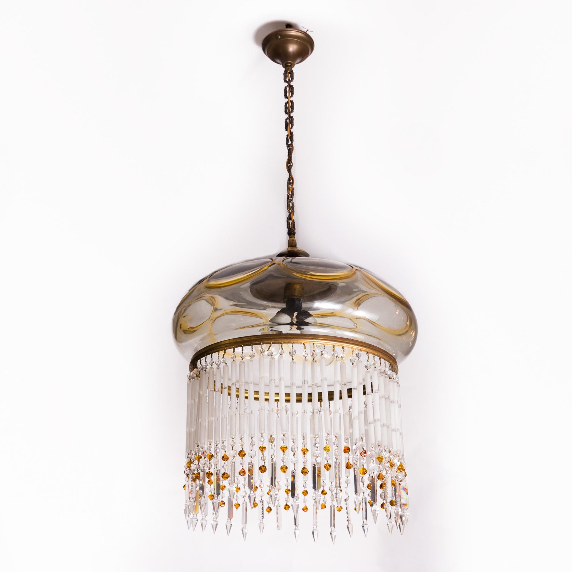 A beautiful, large chandelier with an Art Nouveau character, made circa 1900. It combines the tradition of using light prisms, together with a unique form.

The upper shade of anthracite colored smoke glass, its decoration is made of lens glass