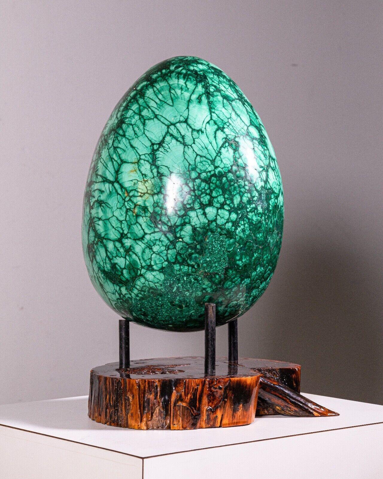 This stunning Belle Epoque Russian Carved Forest Malachite Egg is a work of art. It is carved from solid malachite, a rare and precious mineral, in the shape of a traditional Faberge egg. It is a truly unique and special piece that would make a