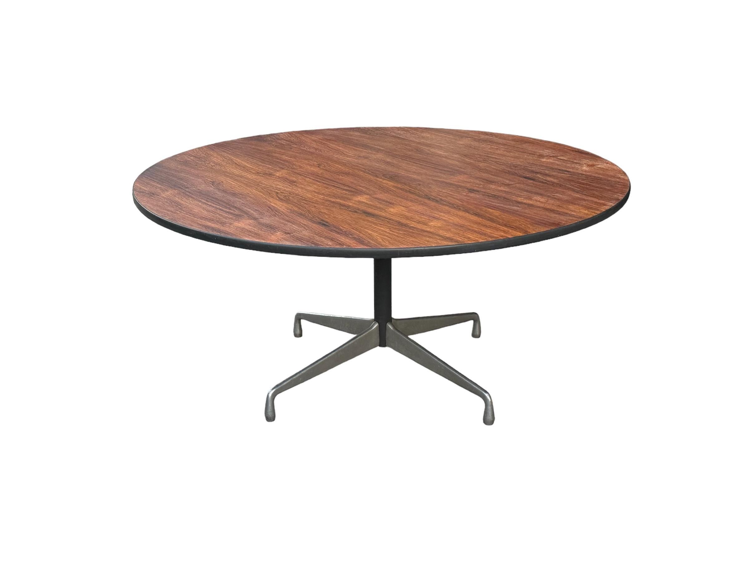 Rare grande table de salle à manger Eames personnalisée par Herman Miller. Surface circulaire lustrée en bois de rose brésilien sur des pieds en aluminium moulé. Des couleurs et des motifs de grain incroyables. D'un diamètre de 5 pieds, il peut
