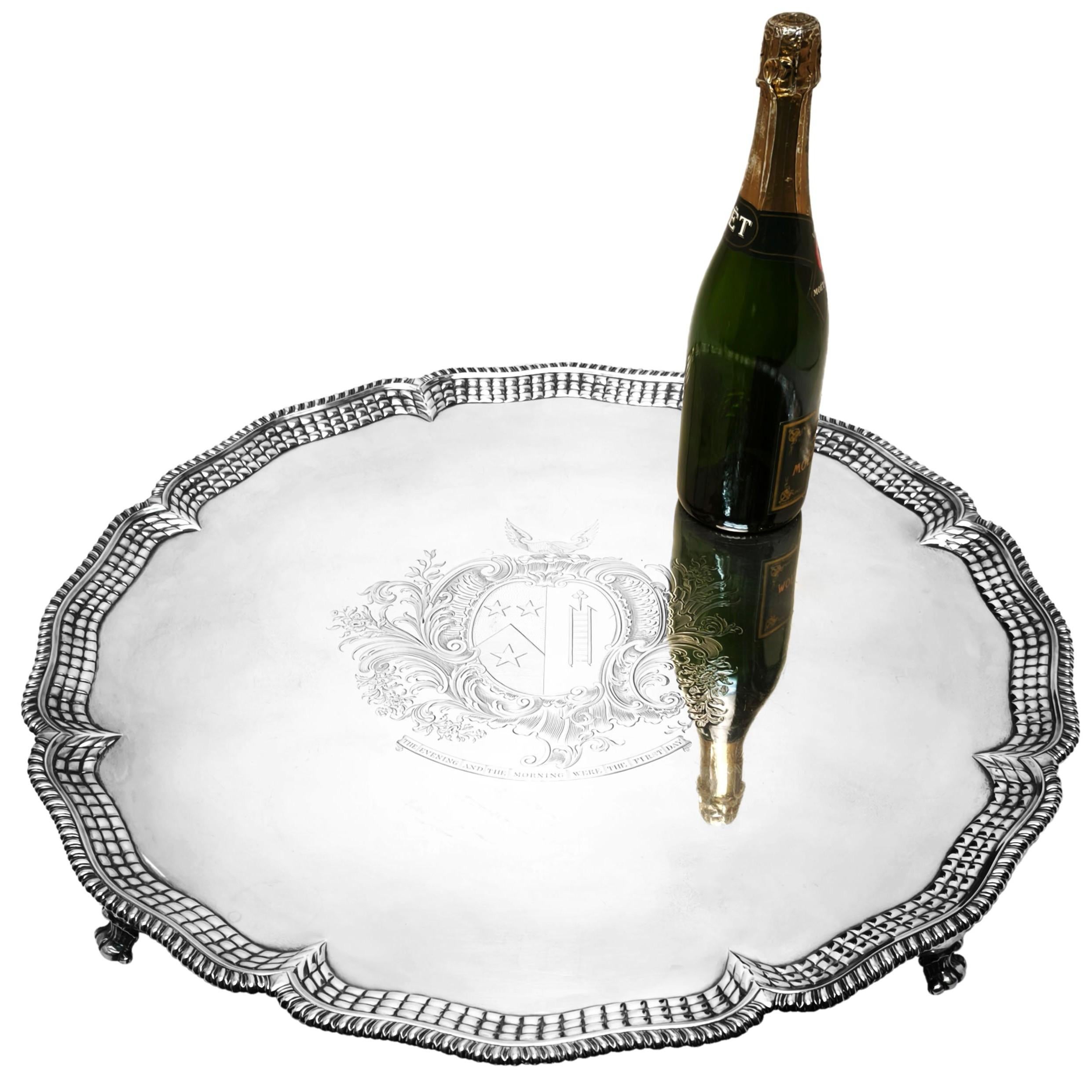 Eine prächtige antike George III Silber Salver von bemerkenswerter Größe und mit einer ungewöhnlichen ziselierten gesteppten Design um den äußeren Rand. Die runde georgianische Platte ist mit einem eindrucksvollen Wappen in der Mitte versehen und
