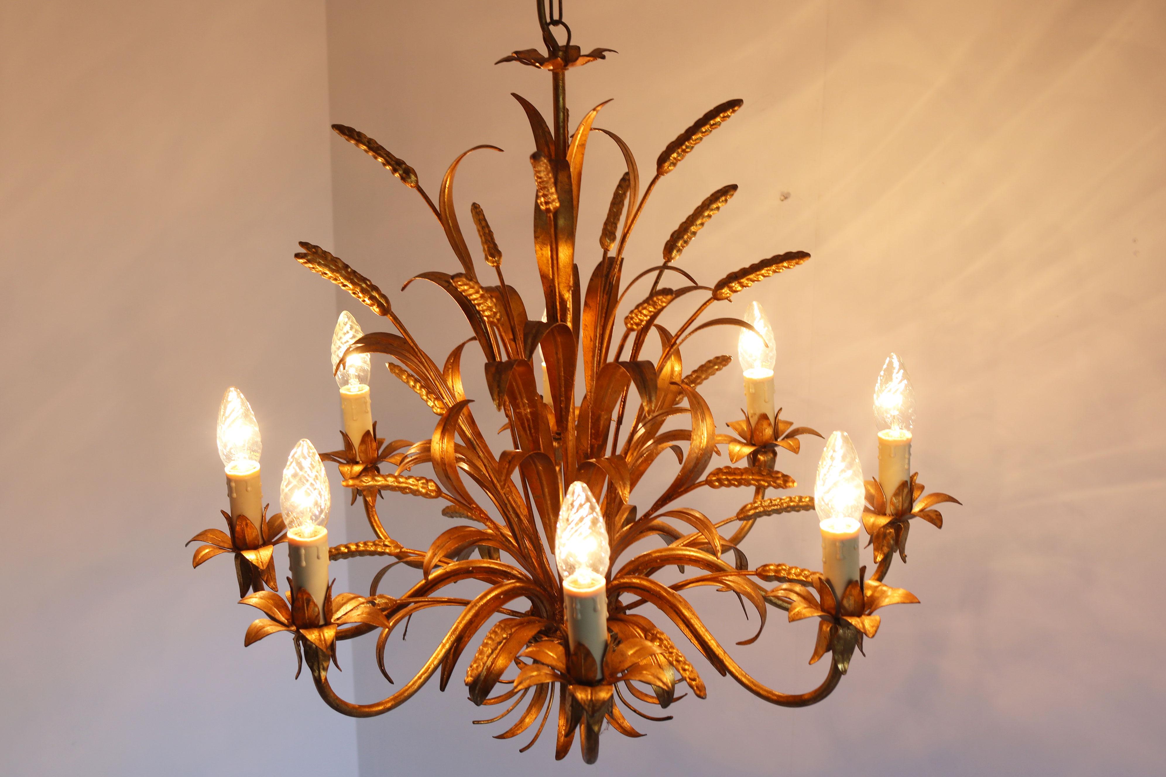 Eleva il tuo spazio con l'eleganza senza tempo di questo lampadario Hollywood Regency, progettato dall'acclamato designer tedesco Hans Kögl nel 1970. Perfetta fusione di opulenza e bellezza ispirata alla natura, questo lampadario crea un'atmosfera