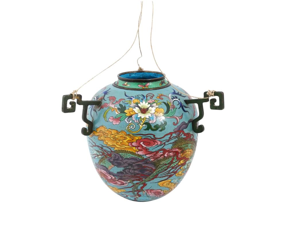 An antique Japanese Meiji period brass oil lamp. Features a vivid cloisonne enamel dragon motif set within a flower design, a distinctive characteristic of Japanese decorative arts during the era. The inclusion of three mounts for hanging suggests a