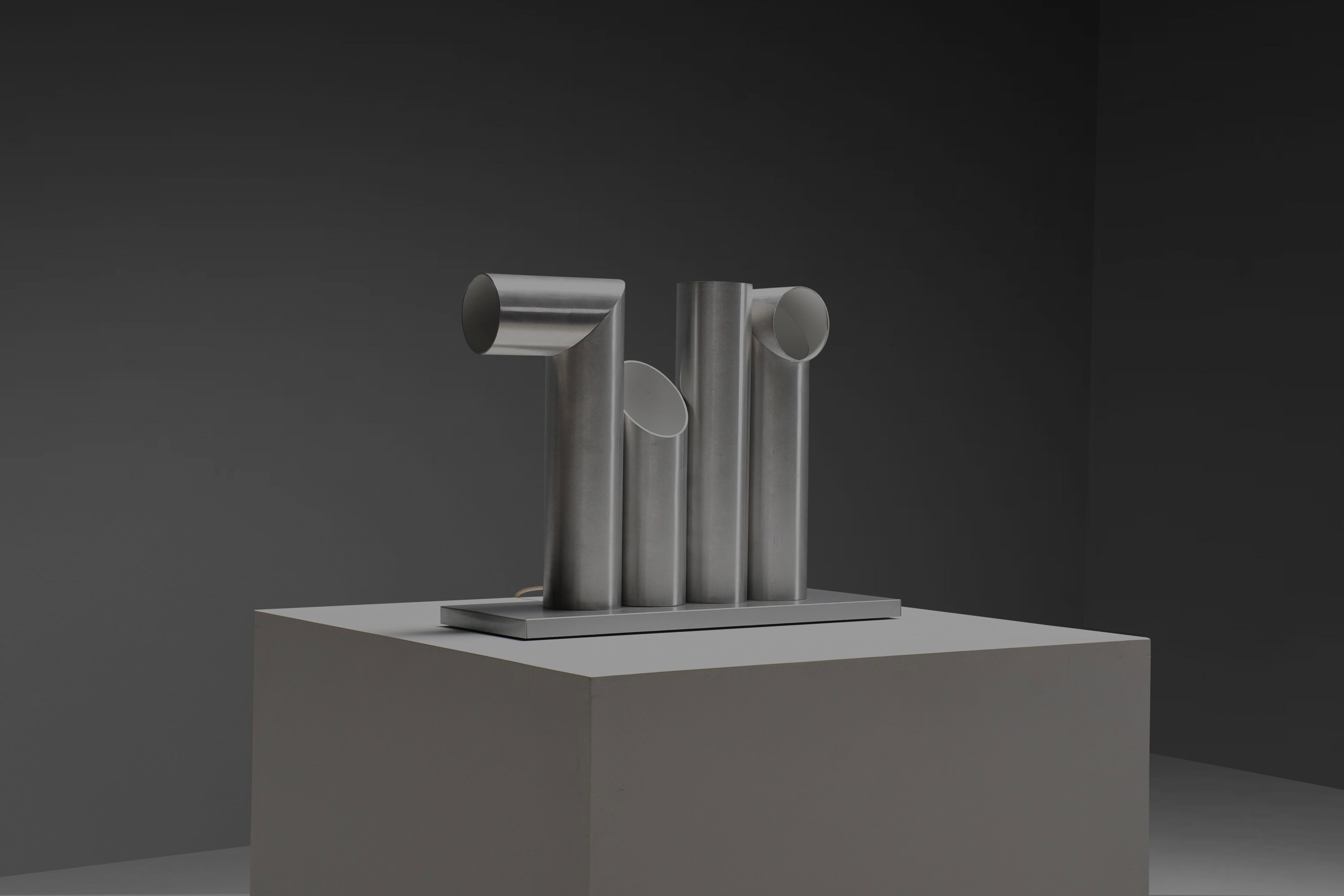 Rarissima lampada da tavolo RAAK 'Light Sculpture' in ottime condizioni.

La lampada è composta da quattro tubi in alluminio anodizzato, che hanno tutti una forma diversa e possono essere scambiati tra loro in infinite combinazioni.

La lampada