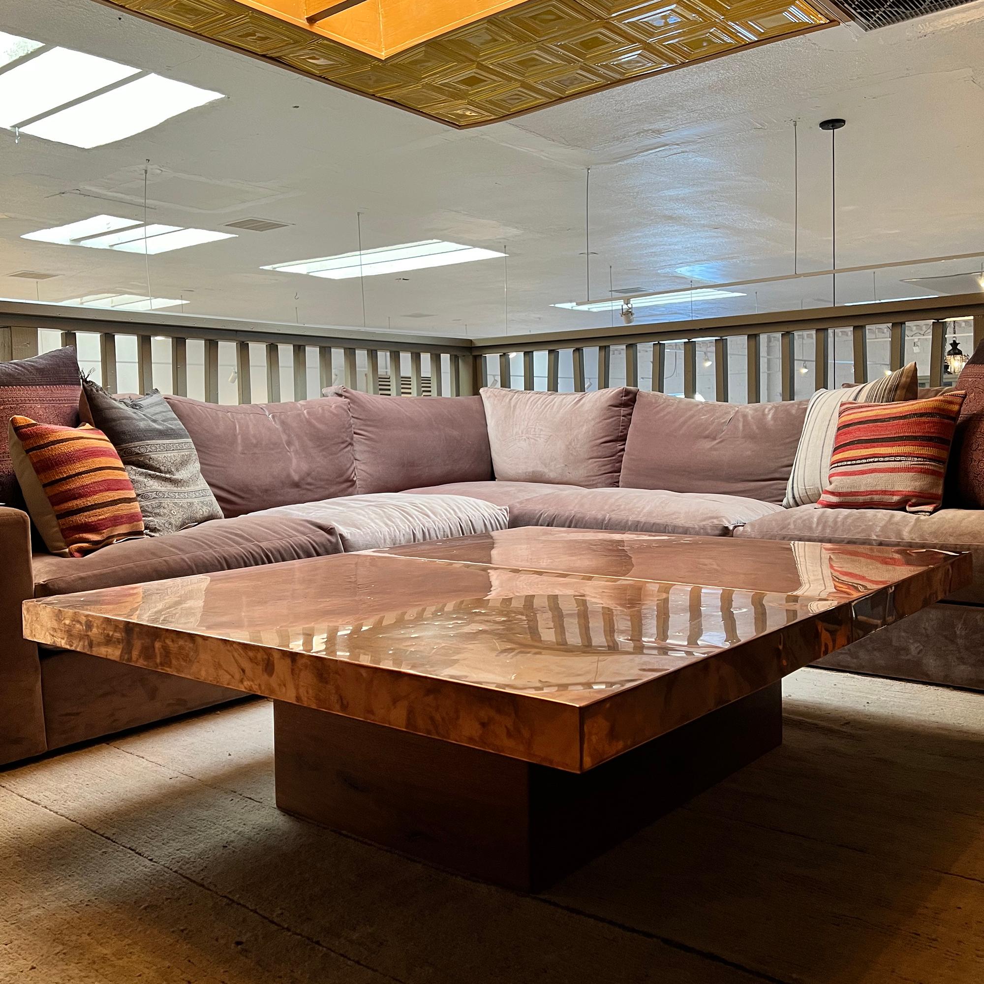 Beautiful and exceptionally large copper clad tabletop resting on a wooden base designed to bring a touch of luxury and character to your living space. This coffee table is in good condition and rare in its style and size.