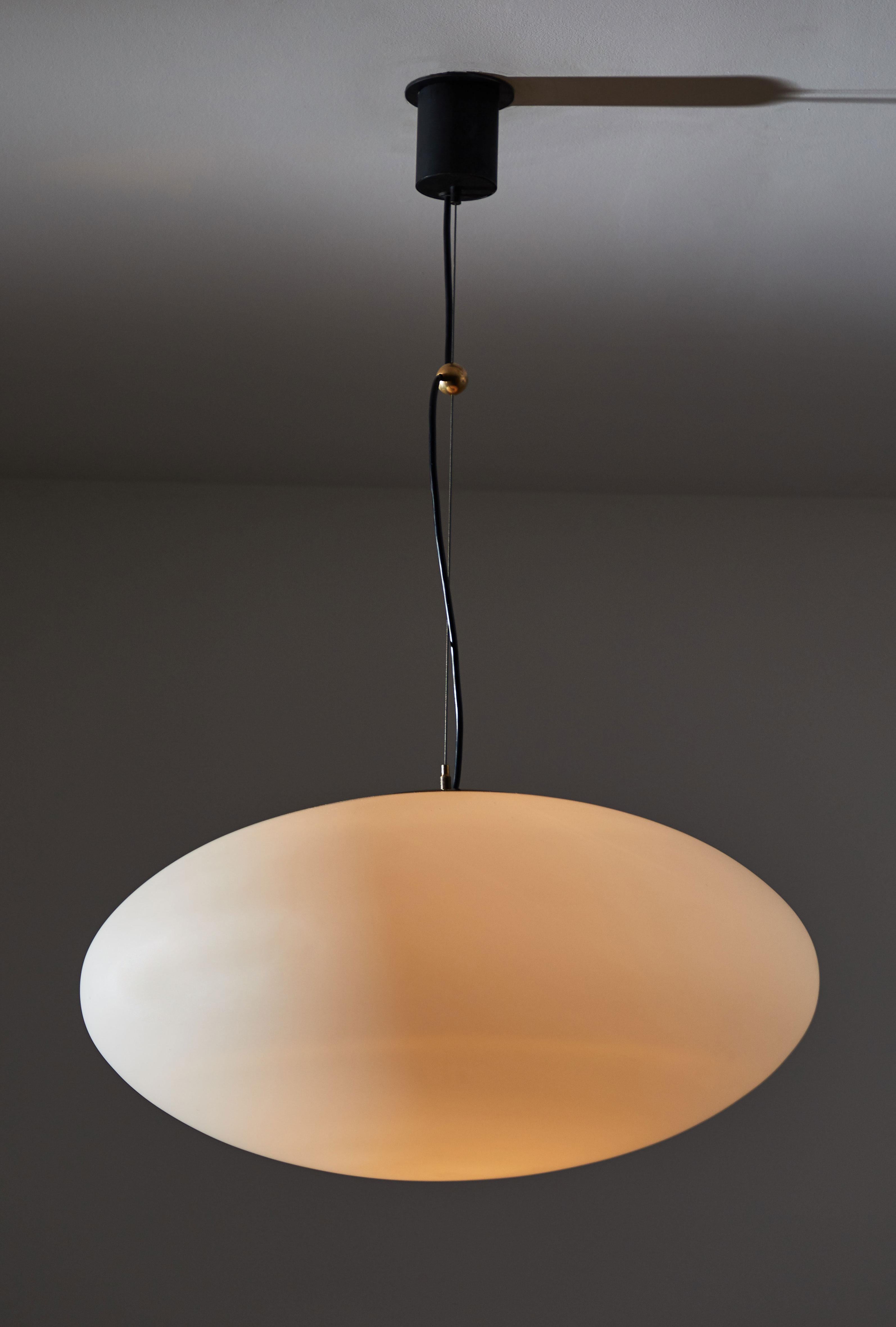 Rare large sized suspension light by Stilnovo. Manufactured in Italy, circa 1950s. Brushed satin glass diffuser, brass hardware, original enameled metal canopy, custom brass ceiling plate. Rewired for US junction boxes. Takes one E27 100w maximum