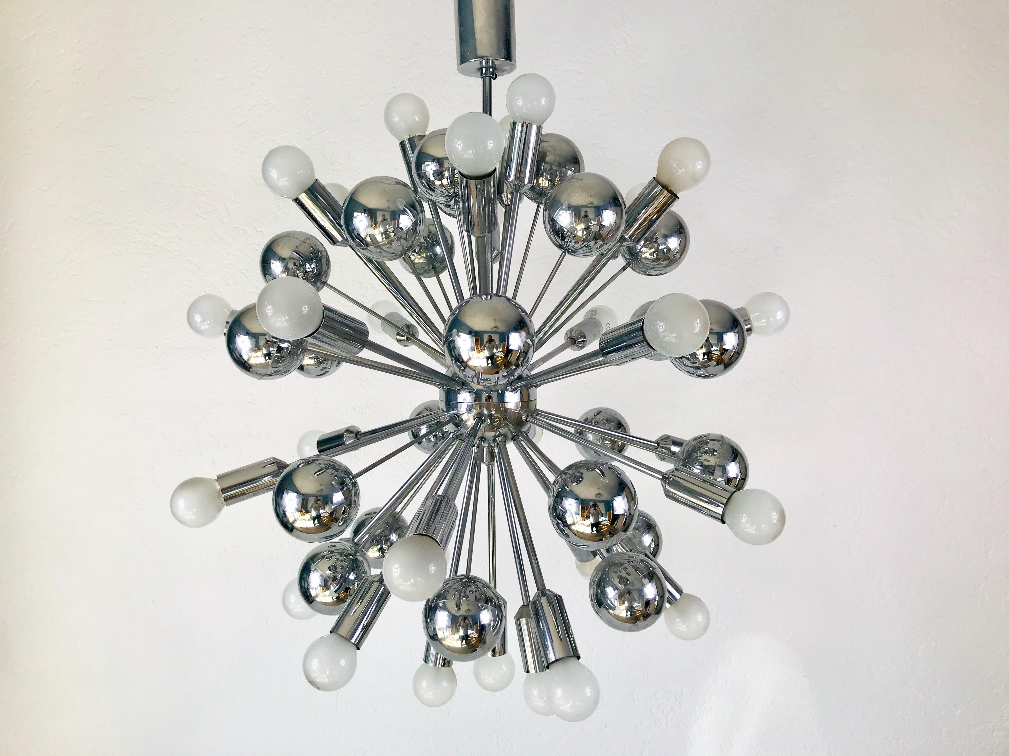 A chrome Sputnik chandelier made in Germany in the 1960s. It is fascinating with its Space Age design and many arms. The body of the light is made of chrome metal, including the arms. 

The light requires E14 light bulbs. Good vintage condition,