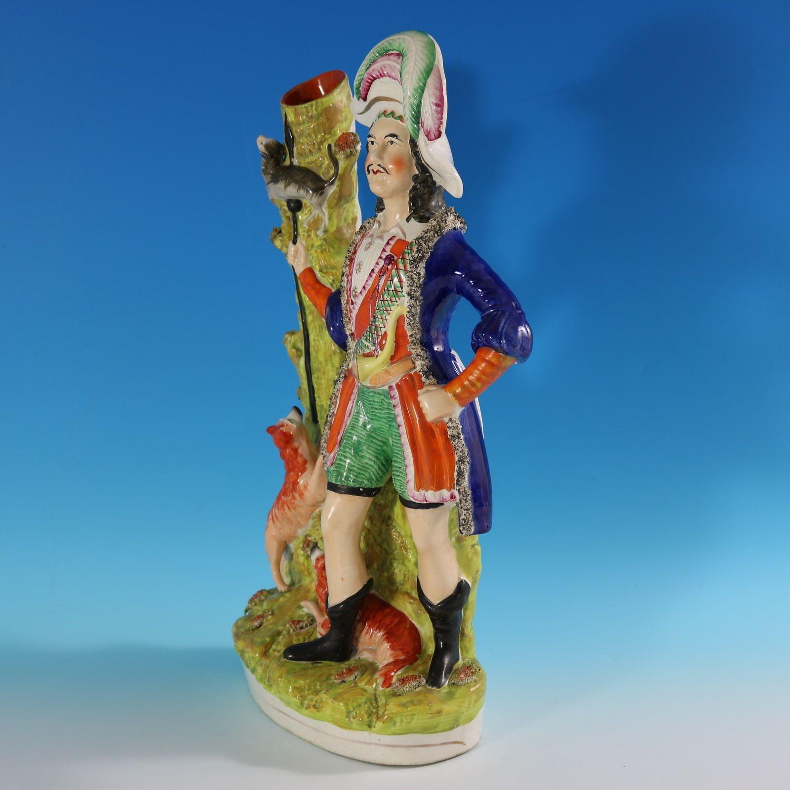 Staffordshire spill vase with a hunting theme which features an otter hunter, his dogs and an otter impaled on his spear. Multi-coloured with underglaze blue version. Dull gilt base line and embellishment. Book reference,'Victorian Staffordshire