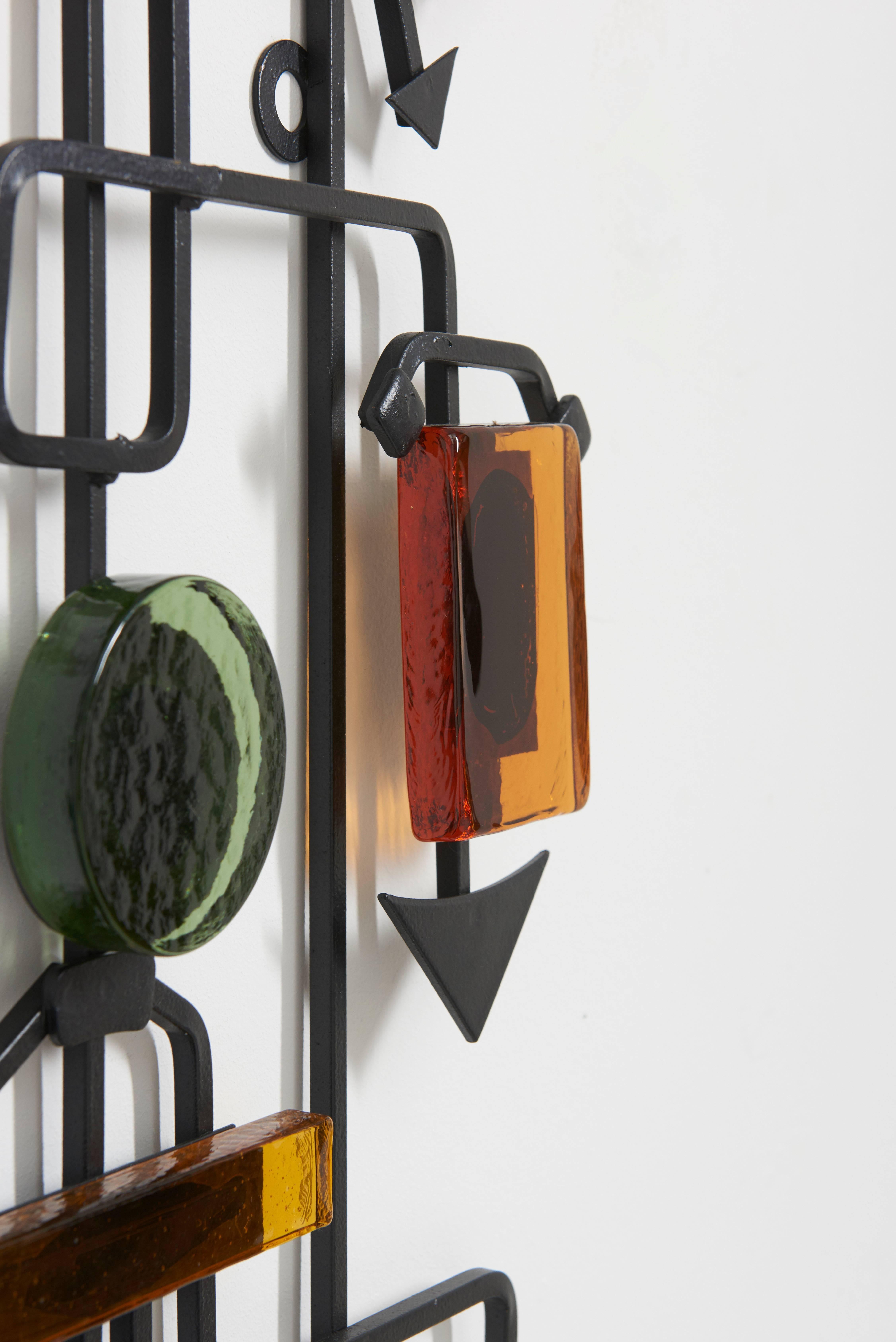 This original Eric Hoglund for Kosta Boda wall sculpture was made of hand-wrought iron and rectangular colored glass pieces in amber, blue and green in various sizes,
Swedish, circa 1960.
