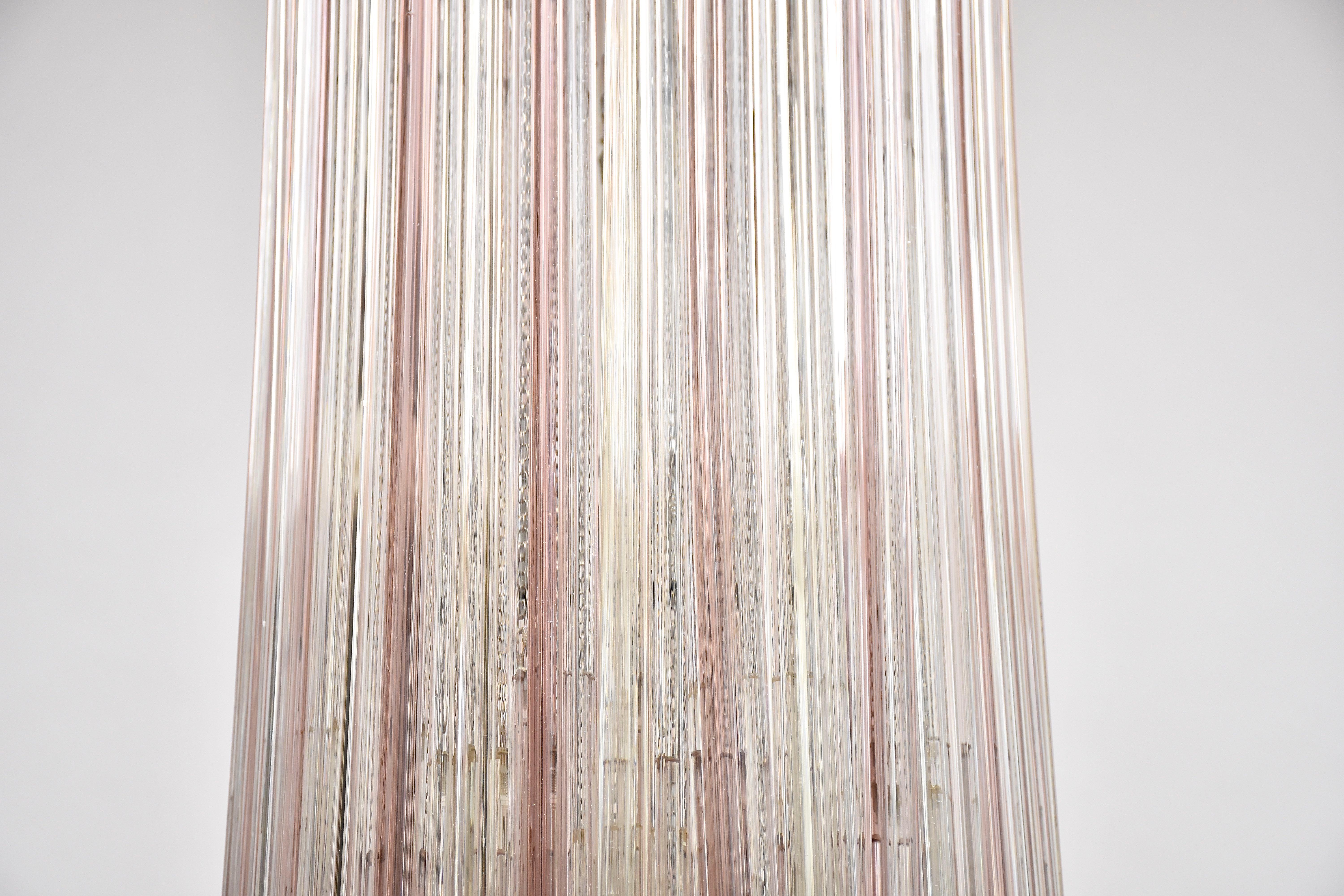 Ein sehr schöner Murano-Kronleuchter 'Trilobo' von Venini.
 Mit 5 Lichtern.
Verziert mit Anhängern aus transparentem und zartfarbigem Murano-Glas, die von Metallketten gehalten werden und an einer weiß lackierten Metallplatte hängen. 
Herkunftsort -