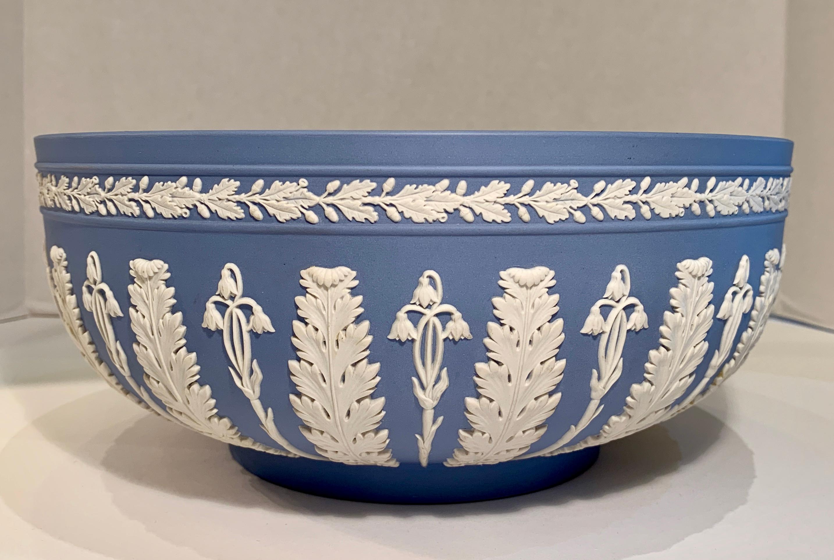 Beautiful estate English Wedgwood Jasperware large bowl in “Wedgwood Blue” features a repeating motif of white, high relief acanthus leaves alternating with floral sprigs and a floral banded border.

Jasperware or jasper ware is a type of pottery