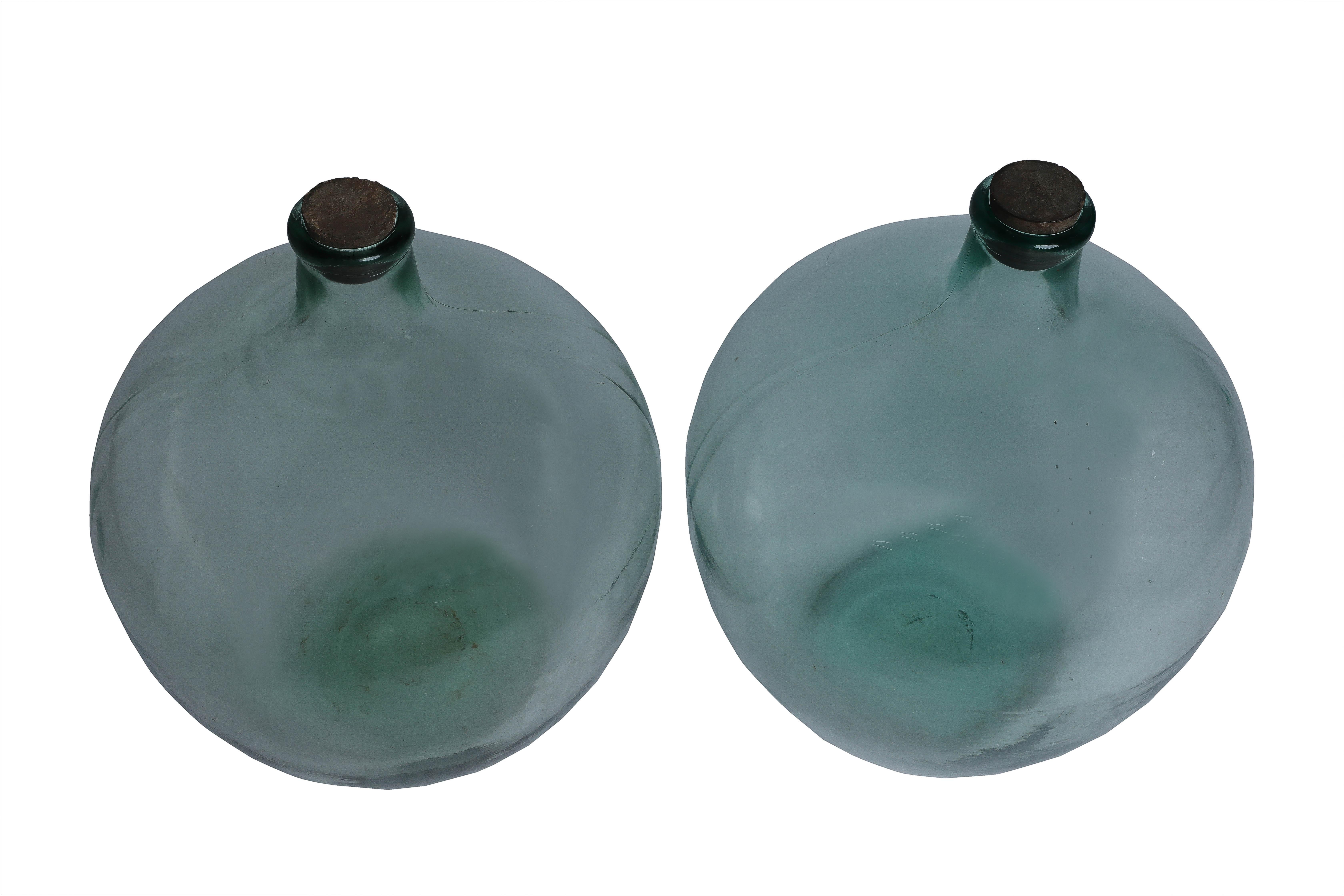 Une paire rare et assortie de récipients à vin en verre vert clair provenant d'Italie. En très bon état. Ils ont leur bouchon d'origine et nous avons ajouté un nouveau bouchon en bois avec une douille électrique pour une ampoule à culot standard.