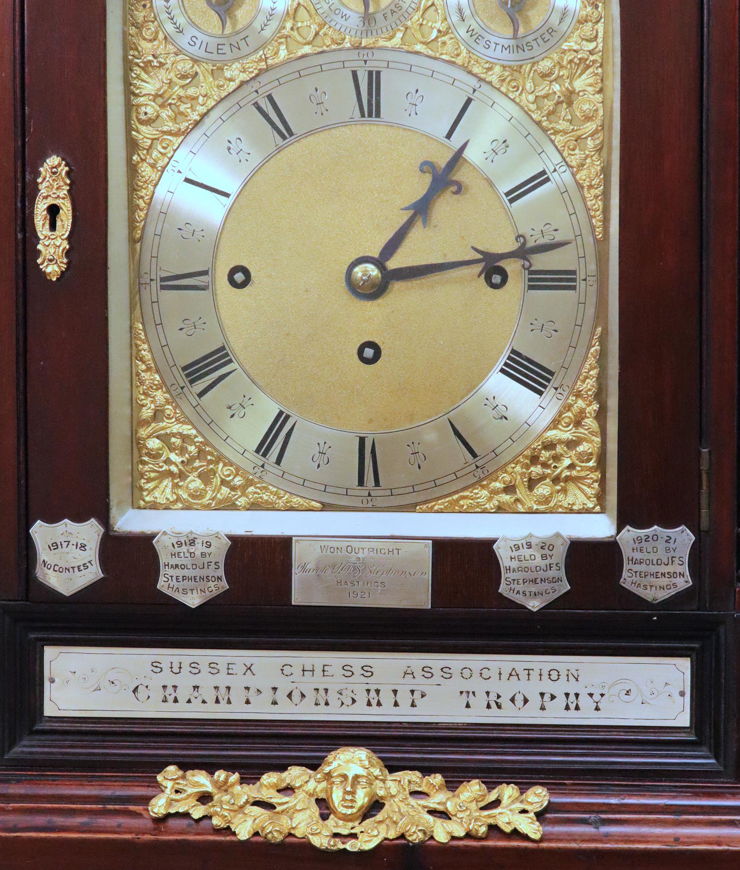 Case:	
The mahogany architectural case has decorative gilt-bronze mounts and engraved sterling silver plaques denoting the winners of the Sussex Chess Association tournaments between 1893-1921.

Dial:	
The multi-piece dial has silver chapter rings,
